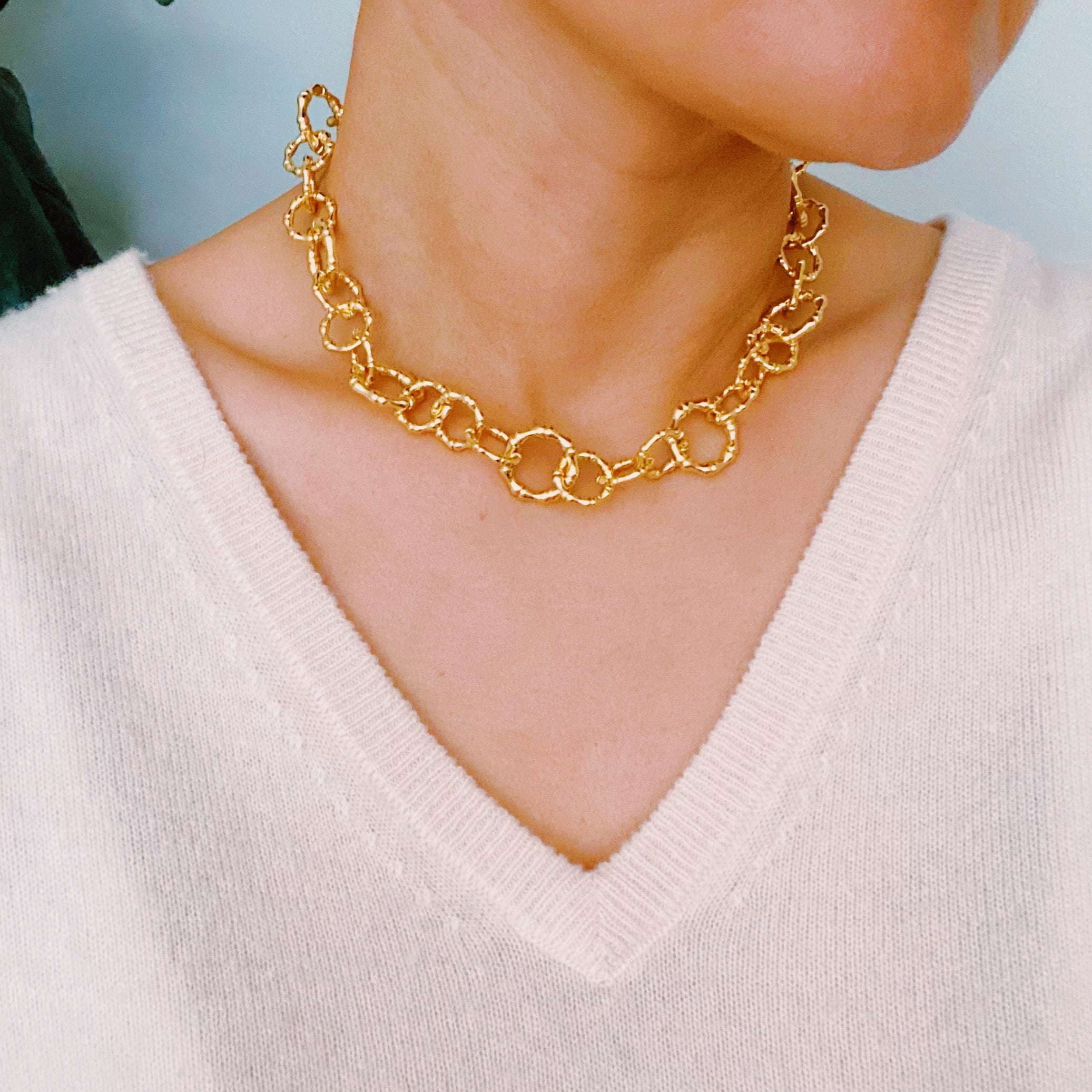 Artfully Linked Chain Necklace featuring varying link sizes and a polished gold finish, elegantly displayed against a soft background.