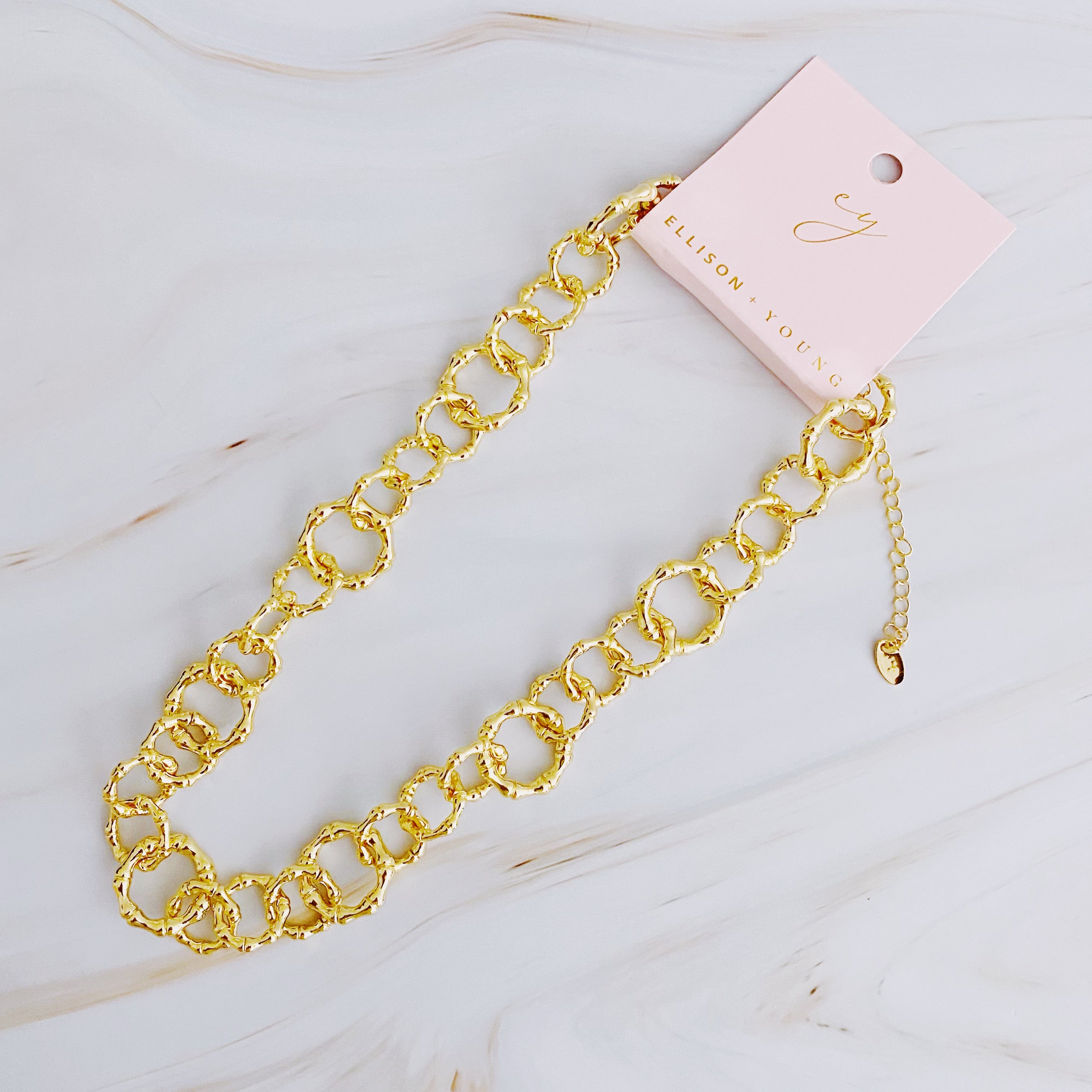 Artfully Linked Chain Necklace featuring varying link sizes and a polished gold finish, elegantly displayed against a soft background.