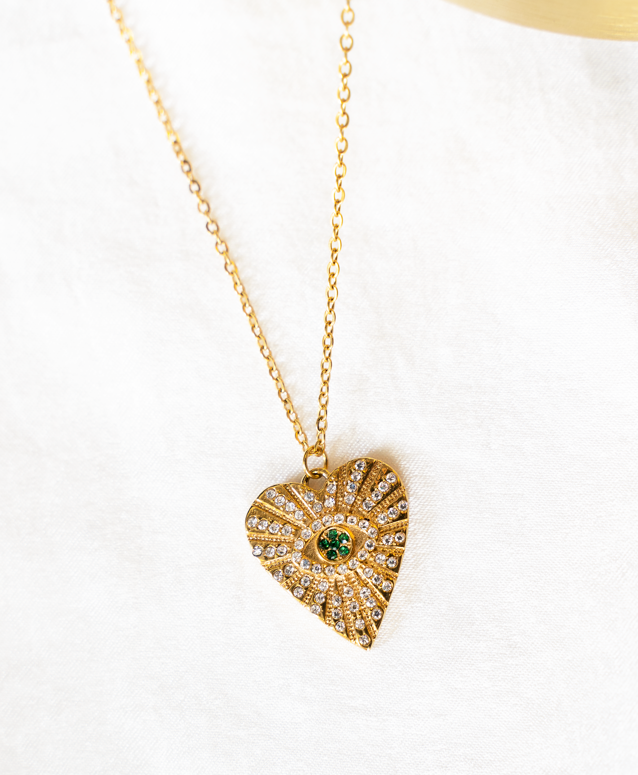 ASHA Heart Necklace featuring sparkling white and emerald crystals on a gold plated heart pendant with a cable chain.