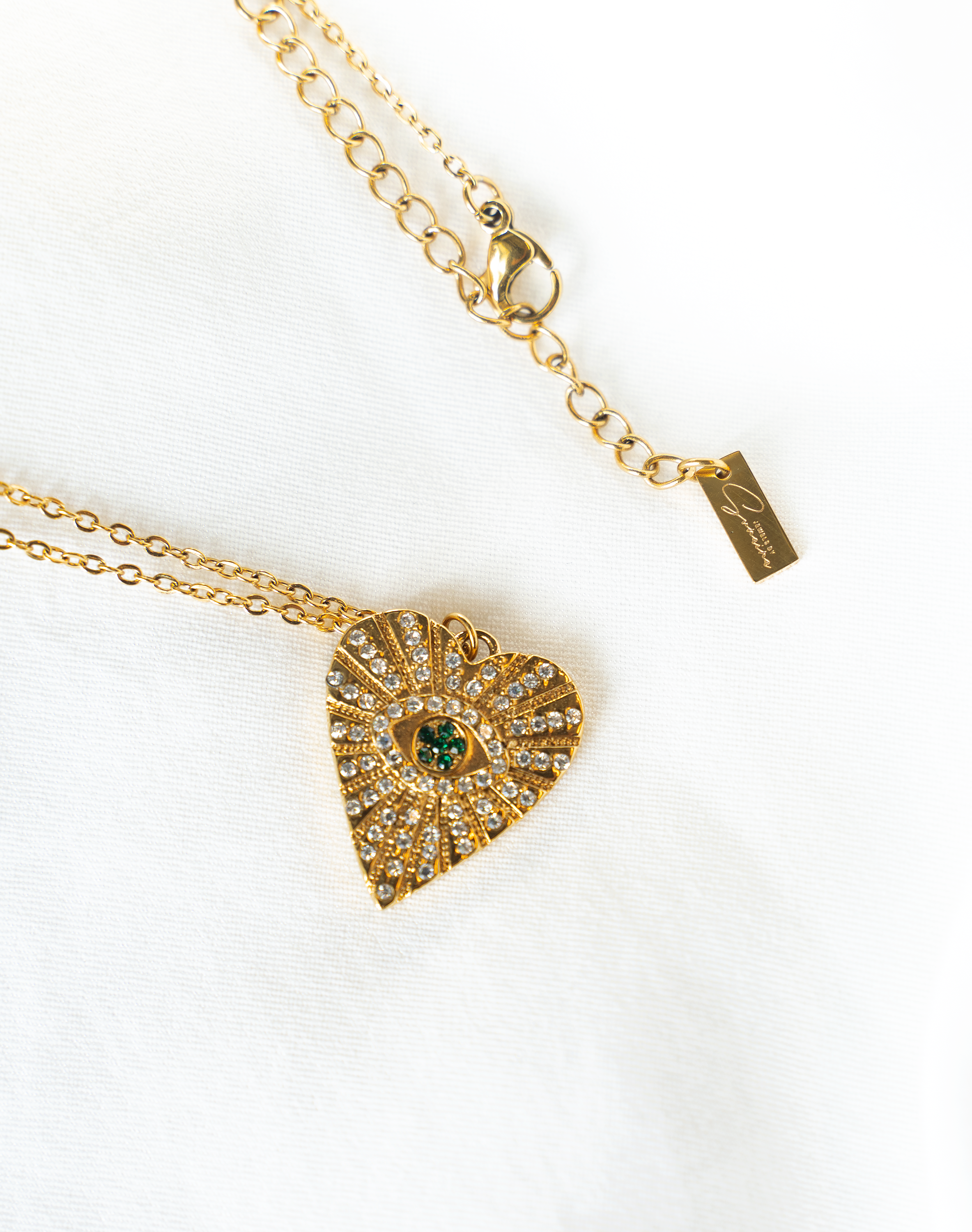 ASHA Heart Necklace featuring sparkling white and emerald crystals on a gold plated heart pendant with a cable chain.