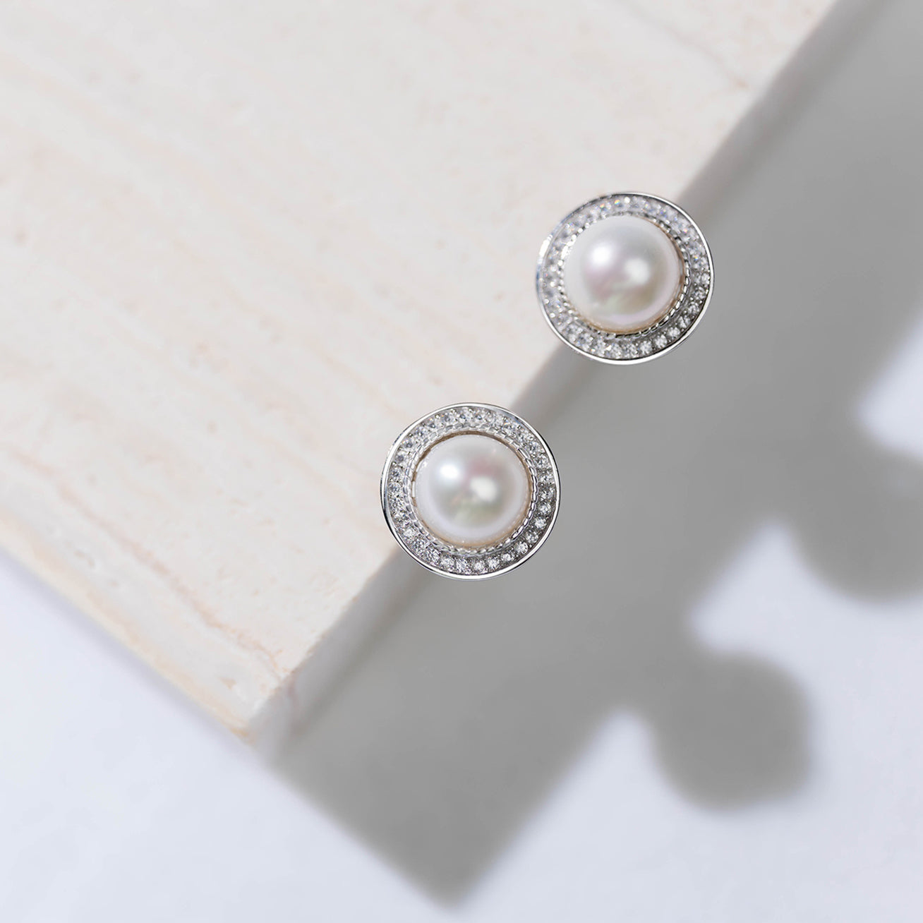 Asian Civilisations Museum Freshwater Pearl Earrings featuring two lustrous pearls in a spiral design, crafted from sterling silver and 18K white gold.