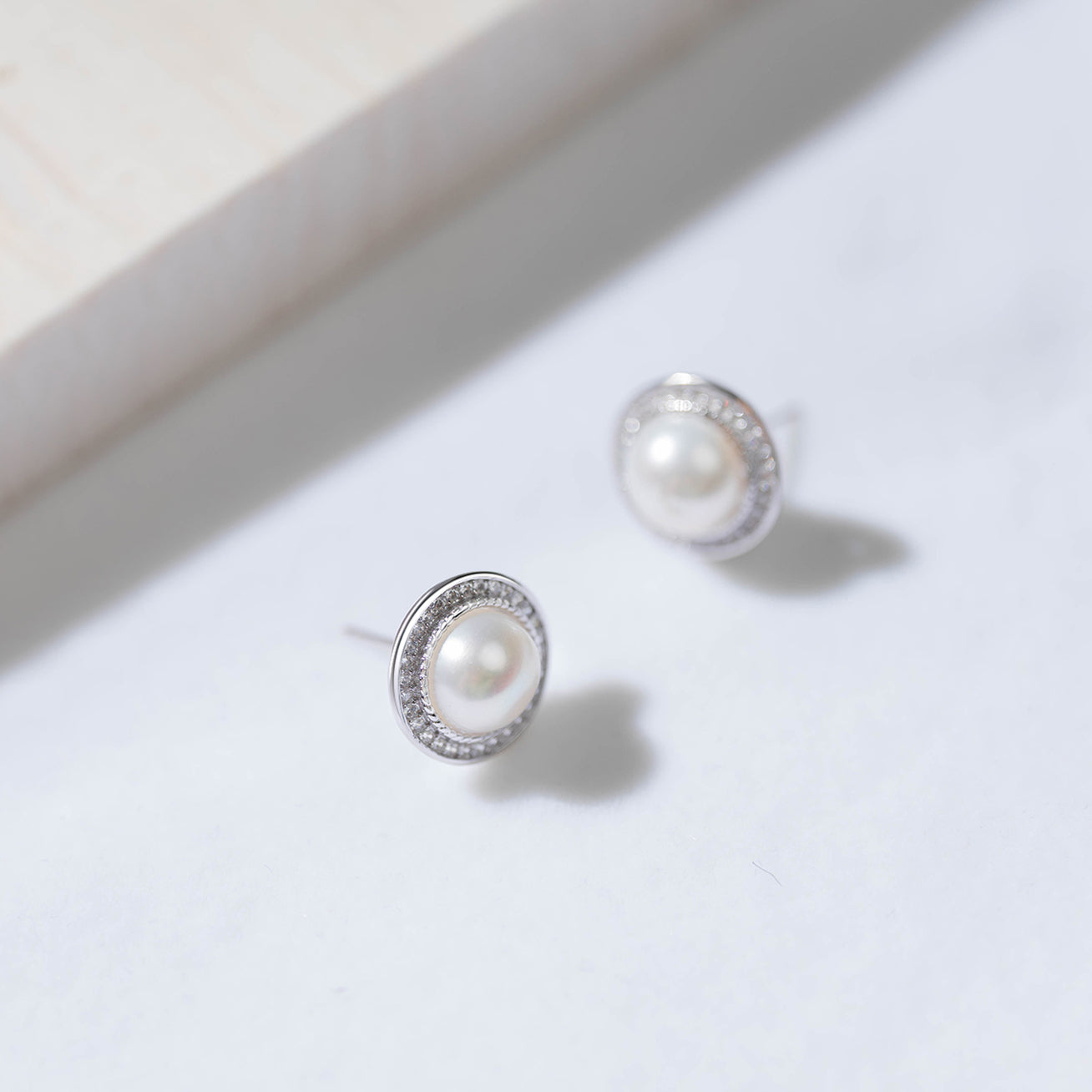 Asian Civilisations Museum Freshwater Pearl Earrings featuring two lustrous pearls in a spiral design, crafted from sterling silver and 18K white gold.