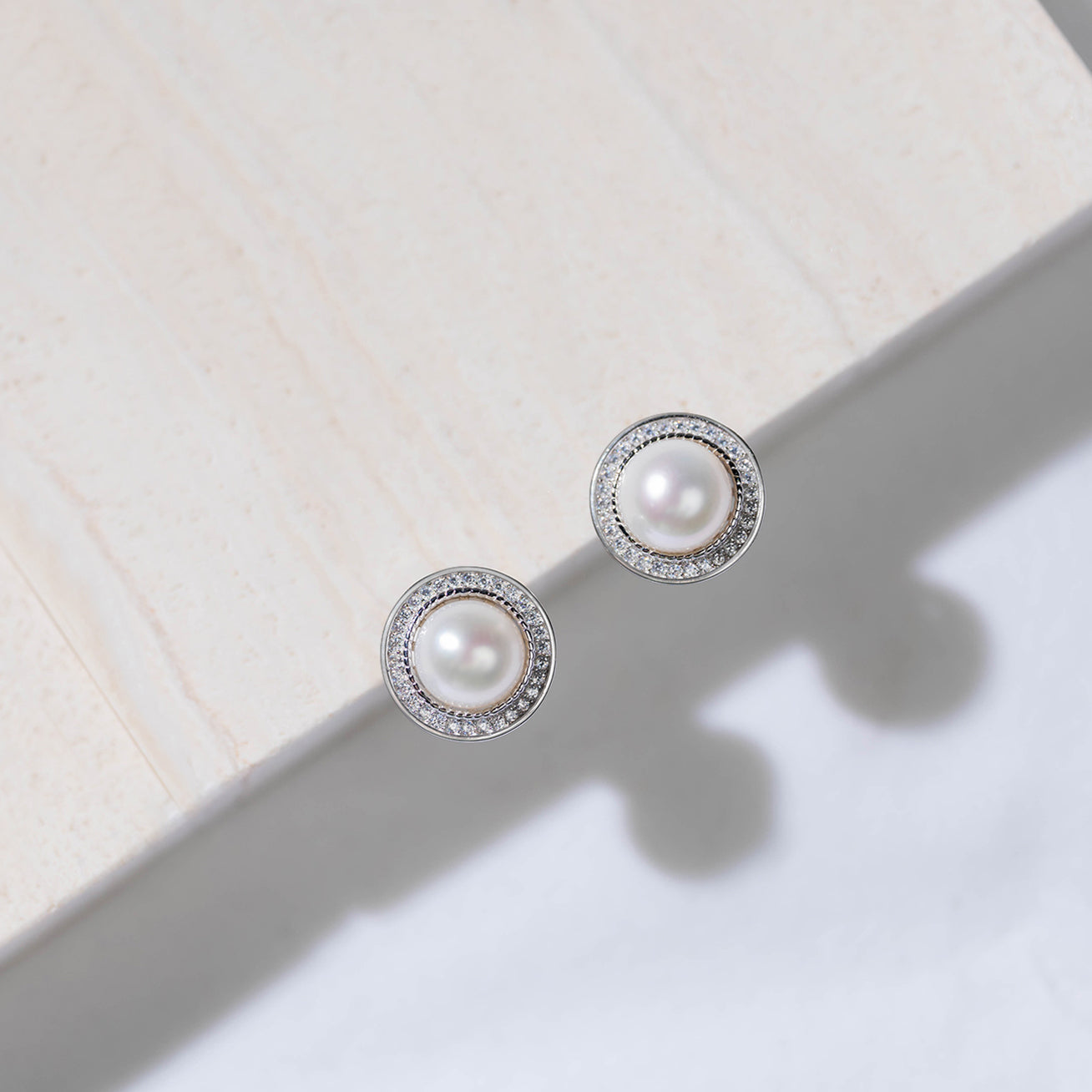 Asian Civilisations Museum Freshwater Pearl Earrings featuring two lustrous pearls in a spiral design, crafted from sterling silver and 18K white gold.