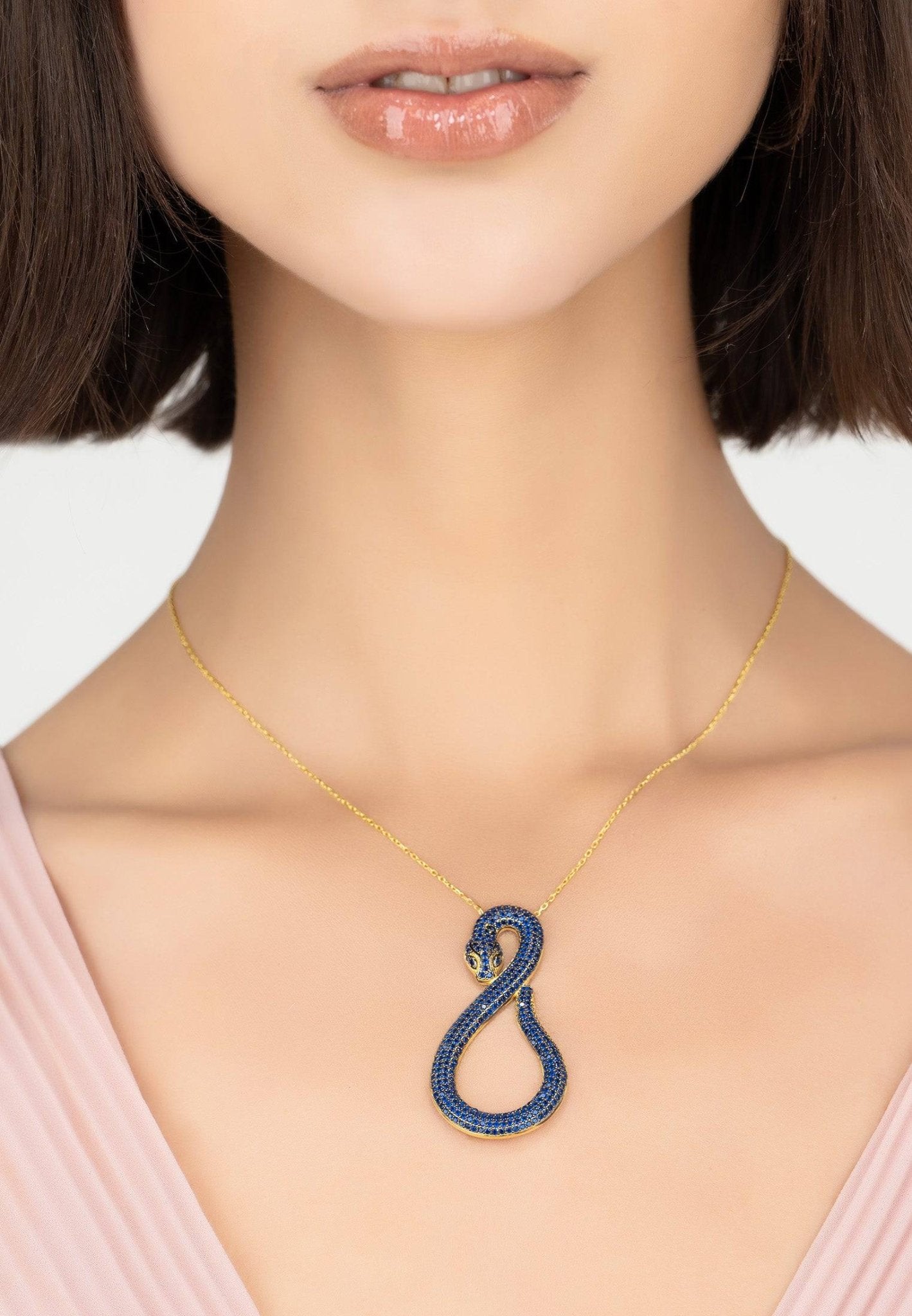 Asp Snake Pendant Necklace in gold with sapphire accents, featuring a snake motif and adjustable chain.