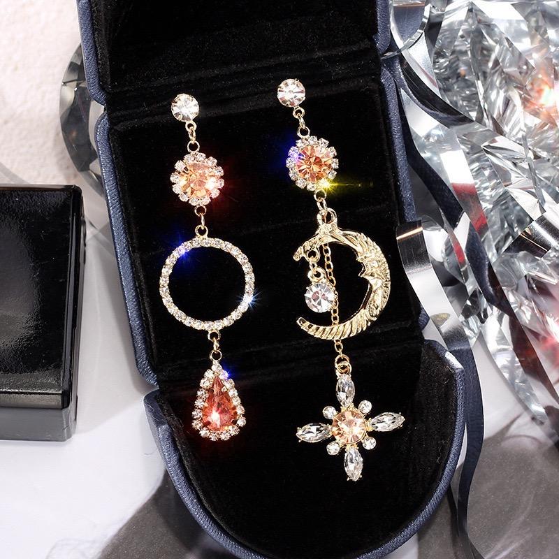 Asymmetric long earrings featuring a sun and moon design, embellished with sparkling rhinestones, showcasing elegance and style.