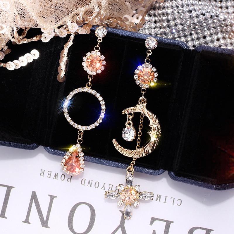 Asymmetric long earrings featuring a sun and moon design, embellished with sparkling rhinestones, showcasing elegance and style.