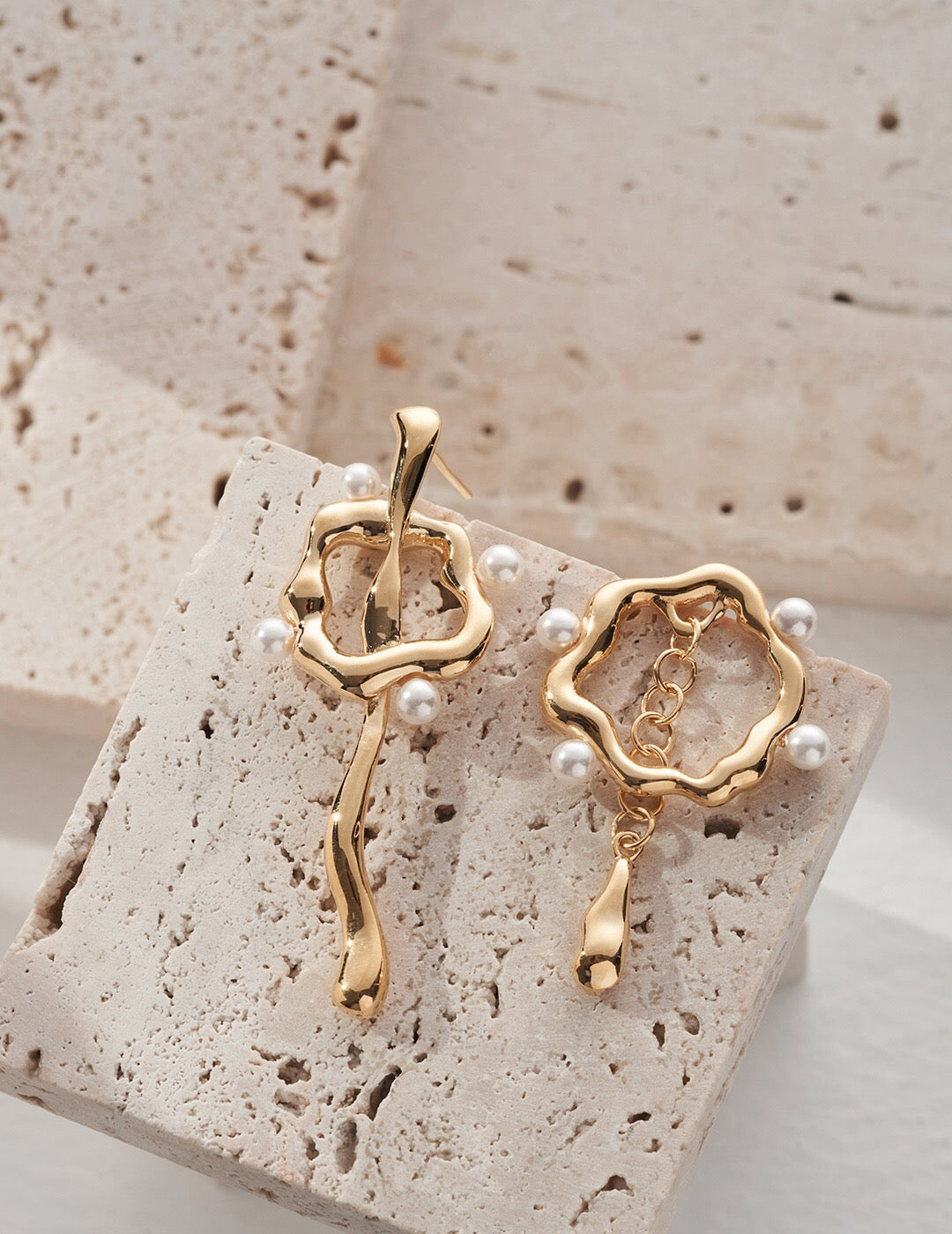 A pair of handmade asymmetrical statement earrings featuring faux pearls and gold vermeil, showcasing a unique and elegant design.