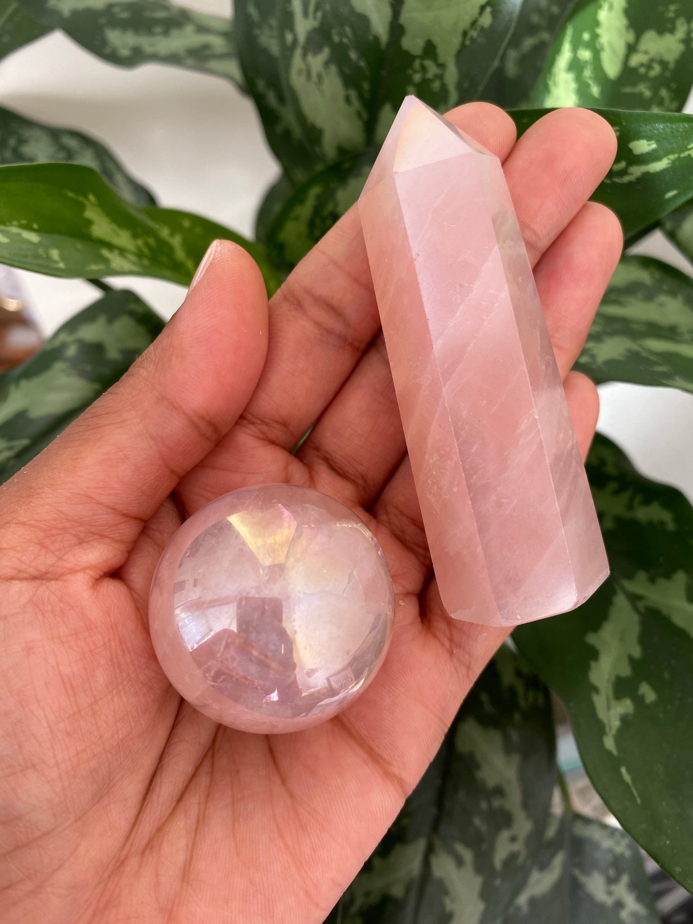 Aura Rose Quartz Sphere on a glass stand, showcasing its soft pink color and smooth surface, symbolizing love and harmony.