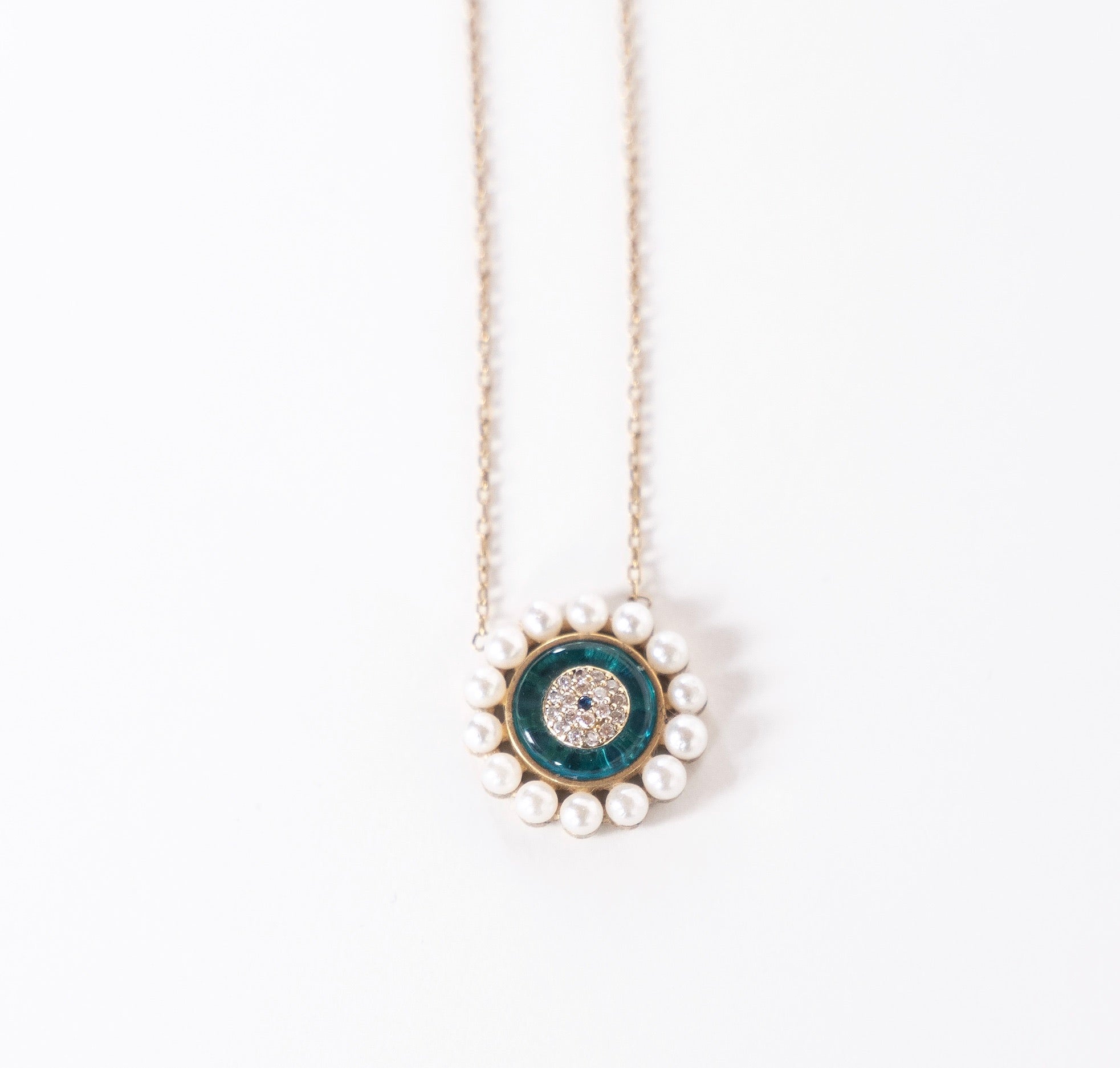 AYRA Necklace featuring mini pearls, evil eye pendant, sea-blue enamel, and cubic zirconia accents on a silver chain.