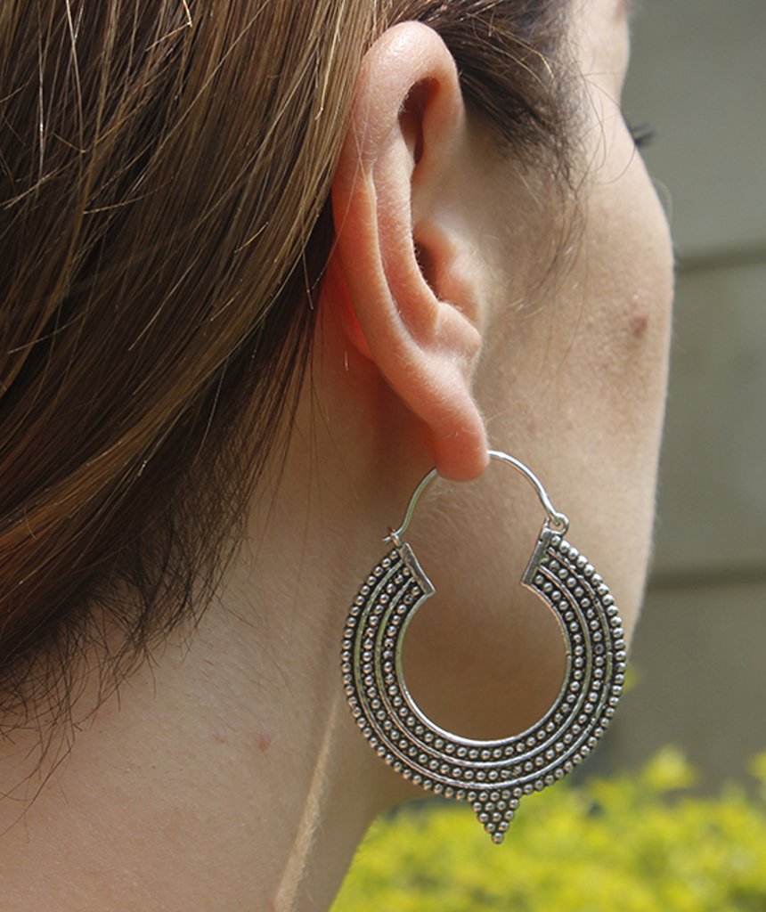 A pair of Aztec Hoop Earrings featuring intricate brass designs, available in three sizes, perfect for sensitive skin.