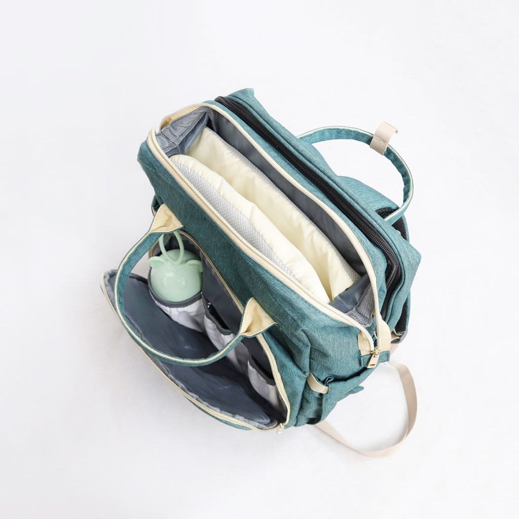 A stylish Baby Crib Backpack showcasing its multi-functional design, featuring a diaper compartment, insulated bottle pocket, and crib setup.