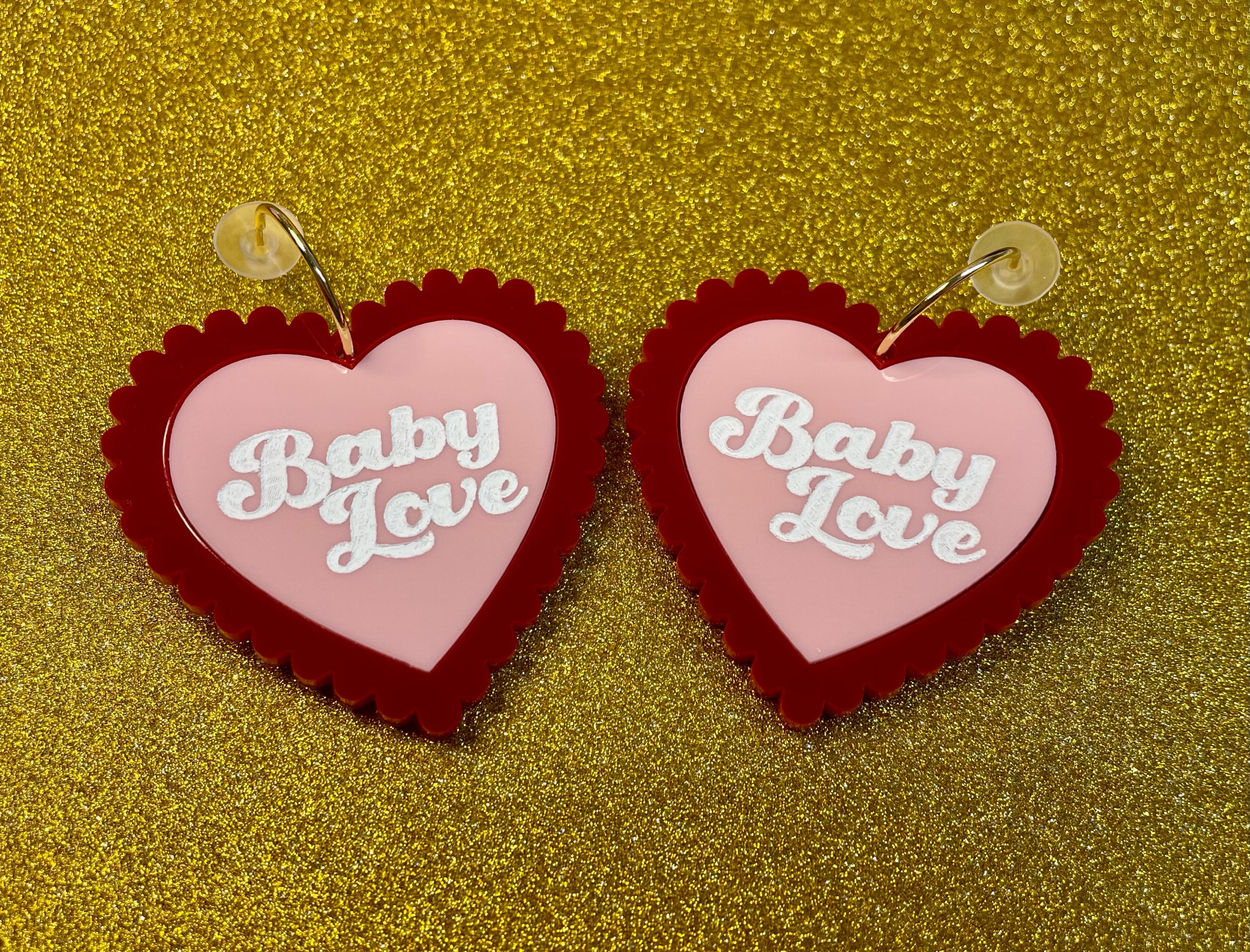 A pair of Baby Love Earrings featuring a vibrant laser cut acrylic design inspired by 1960s and 70s fashion trends, showcasing their unique shape and colors.