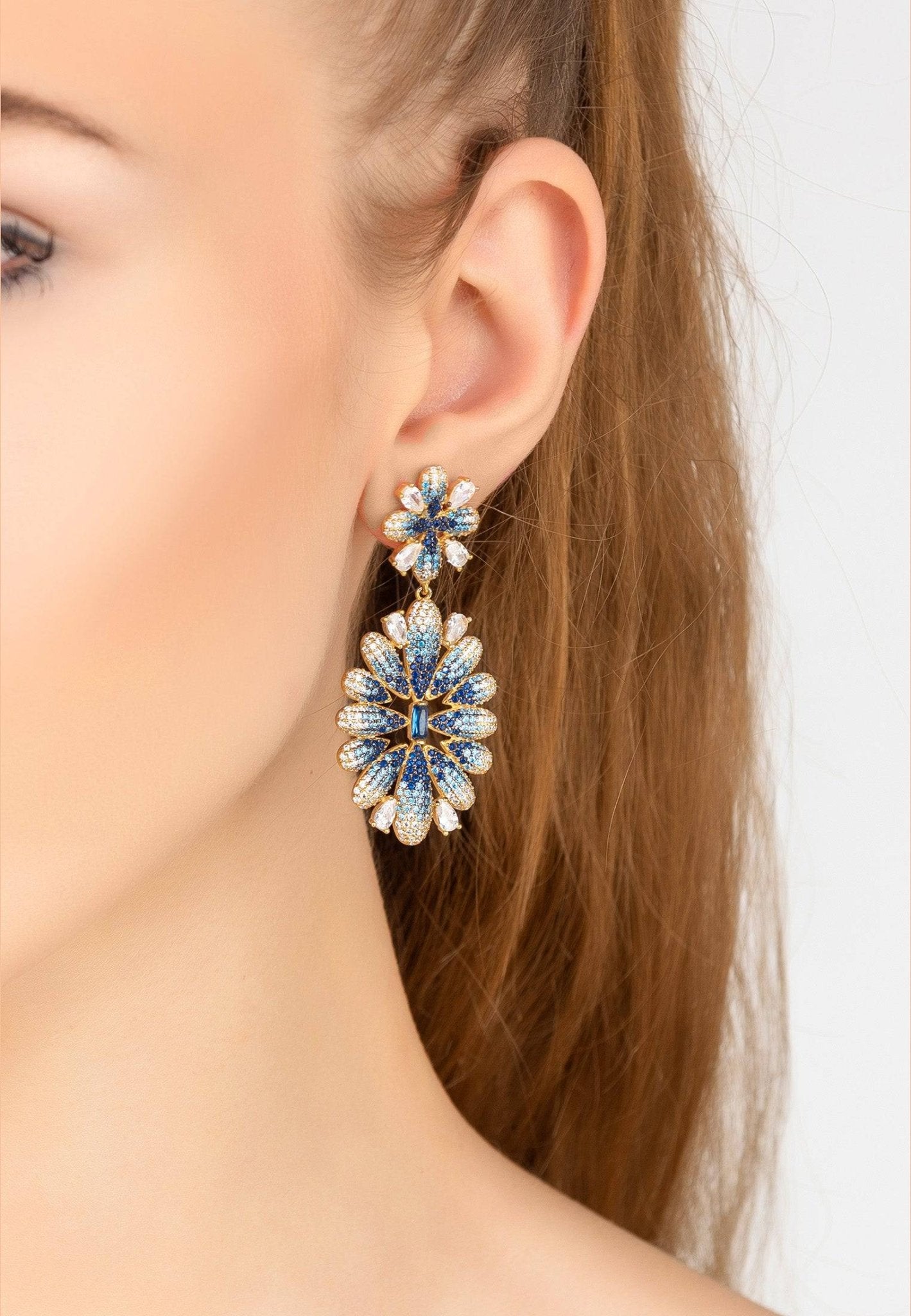 Babylon Flower Drop Earrings in gold and blue featuring intricate flower design with sapphire gemstones and micro pave zircons.