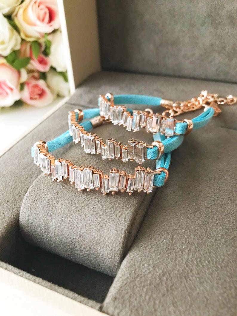 A stylish Baguette Bracelet featuring cubic zirconia stones set in a turquoise leather strap, showcasing a modern and elegant design.