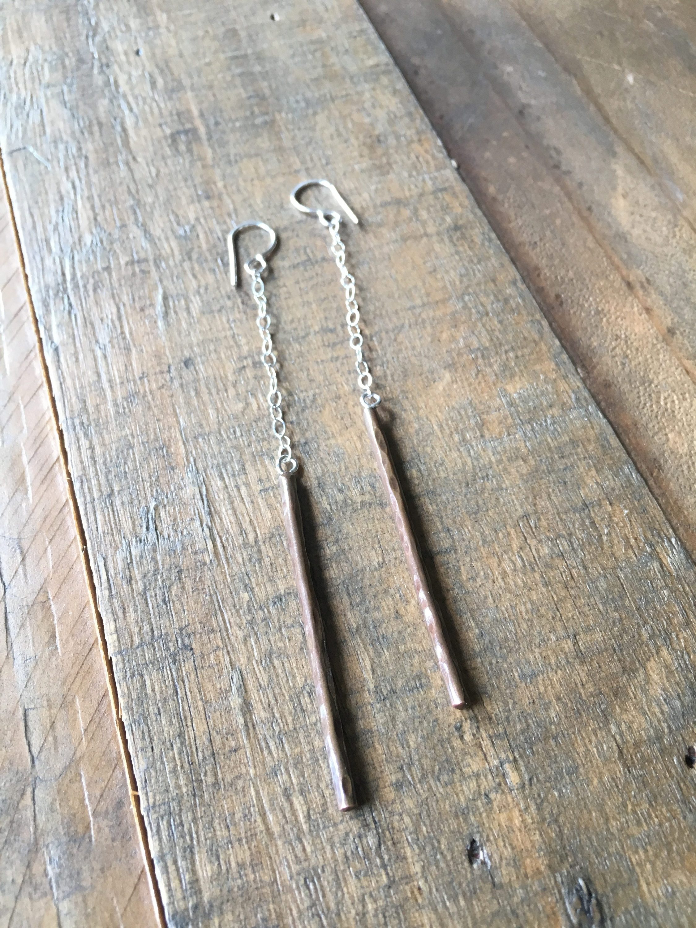 A pair of handmade Balance Earrings featuring rustic textured wire and a lightweight cable chain, available in various finishes.