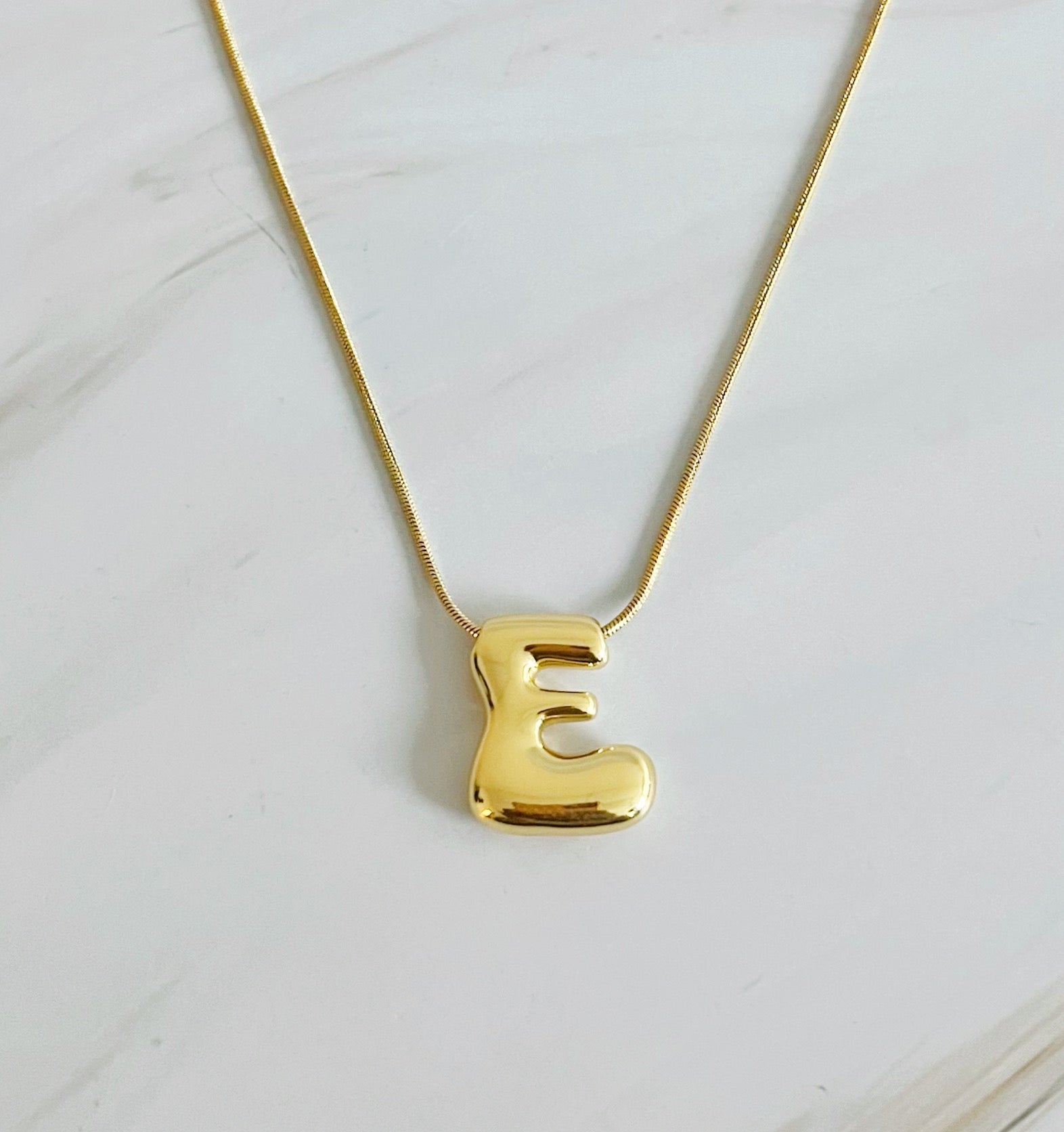 A stylish Balloon Letter Initial Necklace featuring a gold plated initial pendant on a delicate chain.