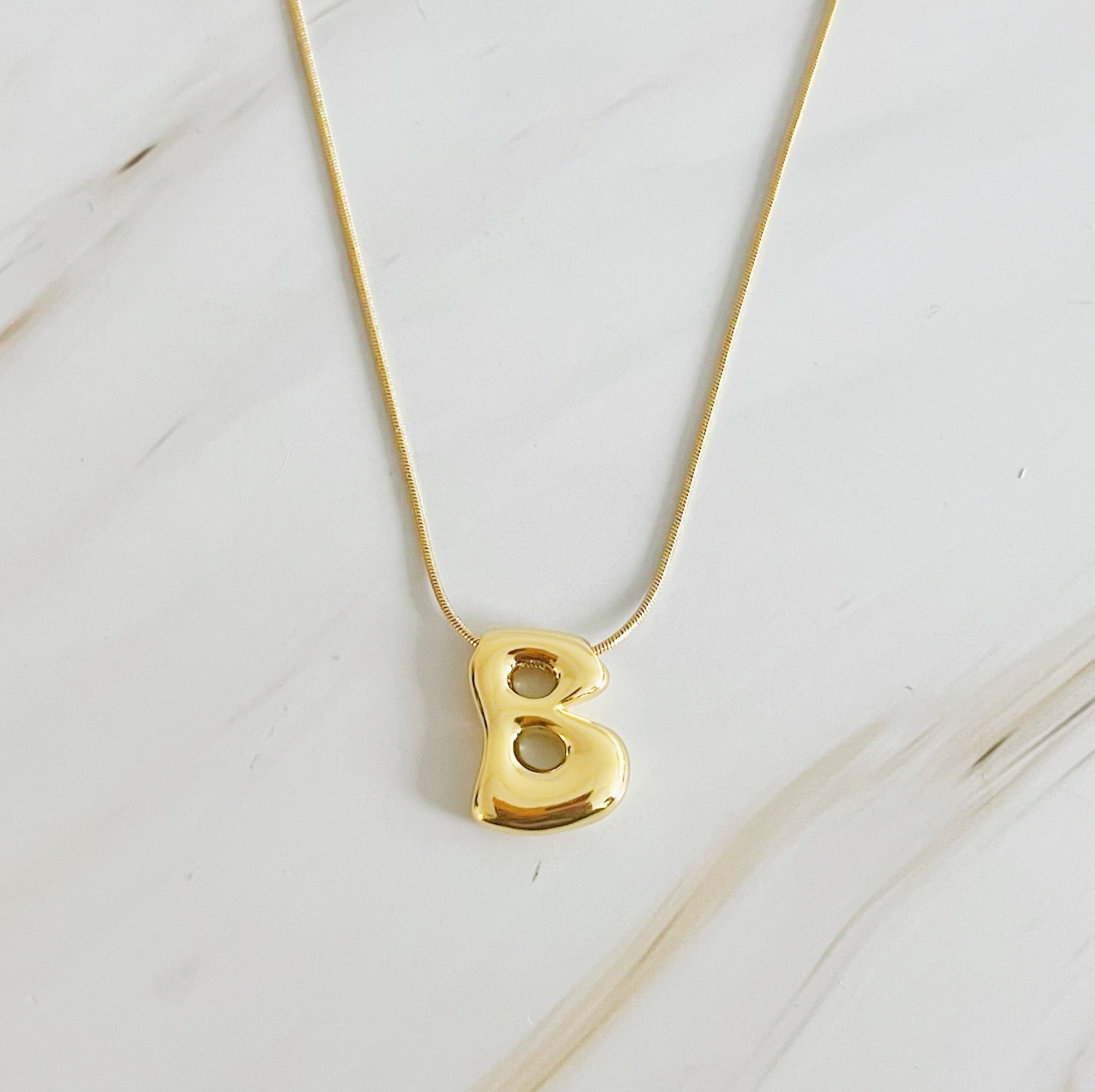 A stylish Balloon Letter Initial Necklace featuring a gold plated initial pendant on a delicate chain.