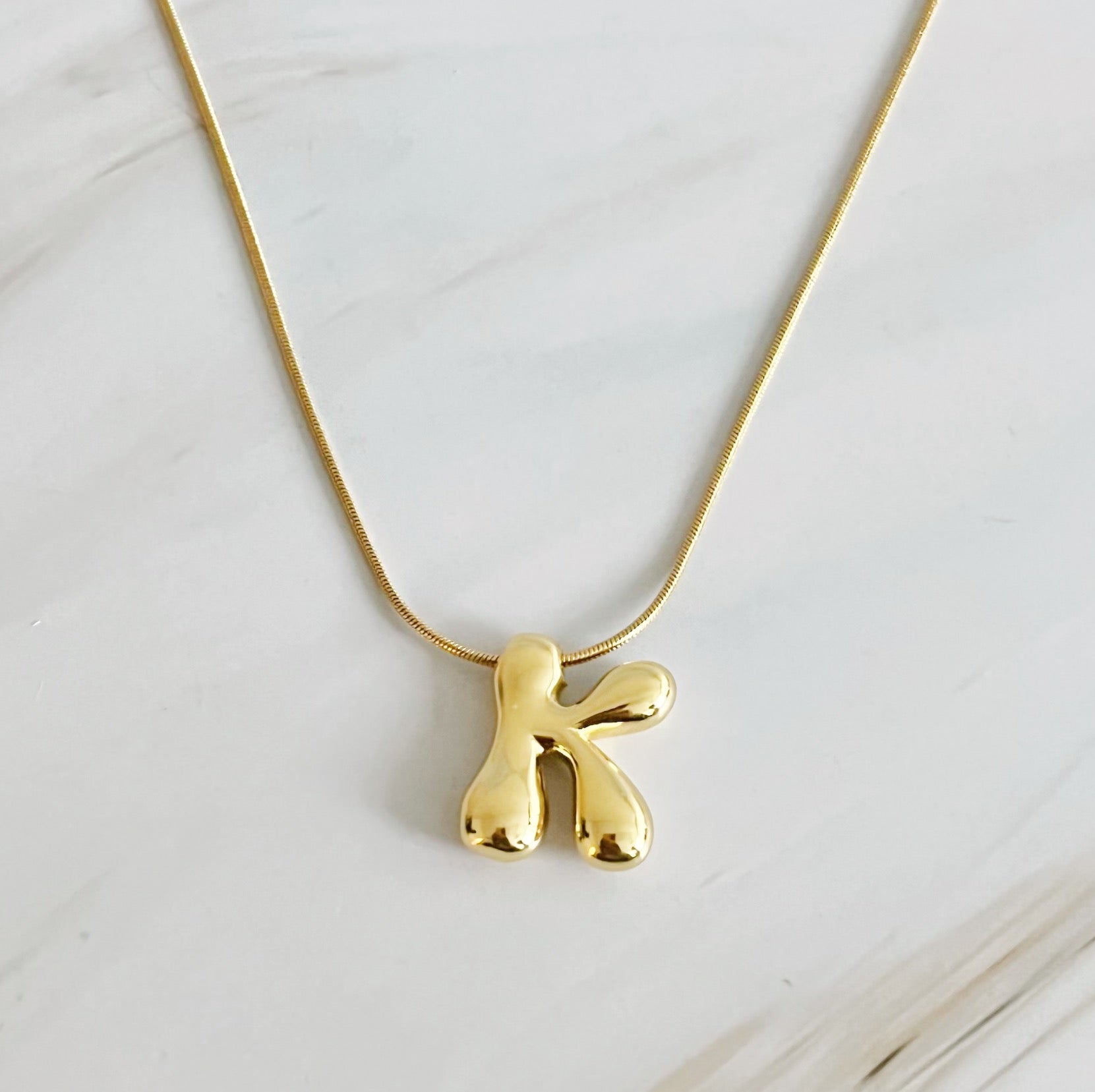 A stylish Balloon Letter Initial Necklace featuring a gold plated initial pendant on a delicate chain.