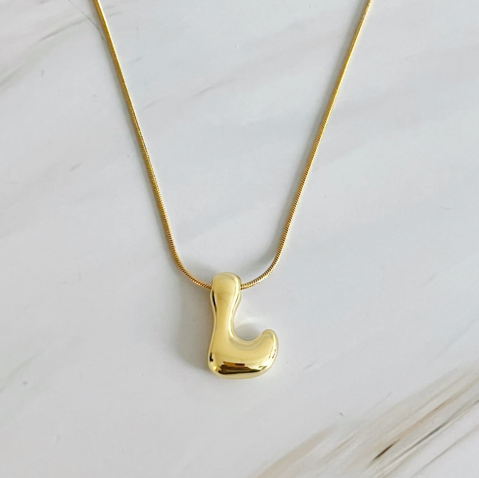 A stylish Balloon Letter Initial Necklace featuring a gold plated initial pendant on a delicate chain.