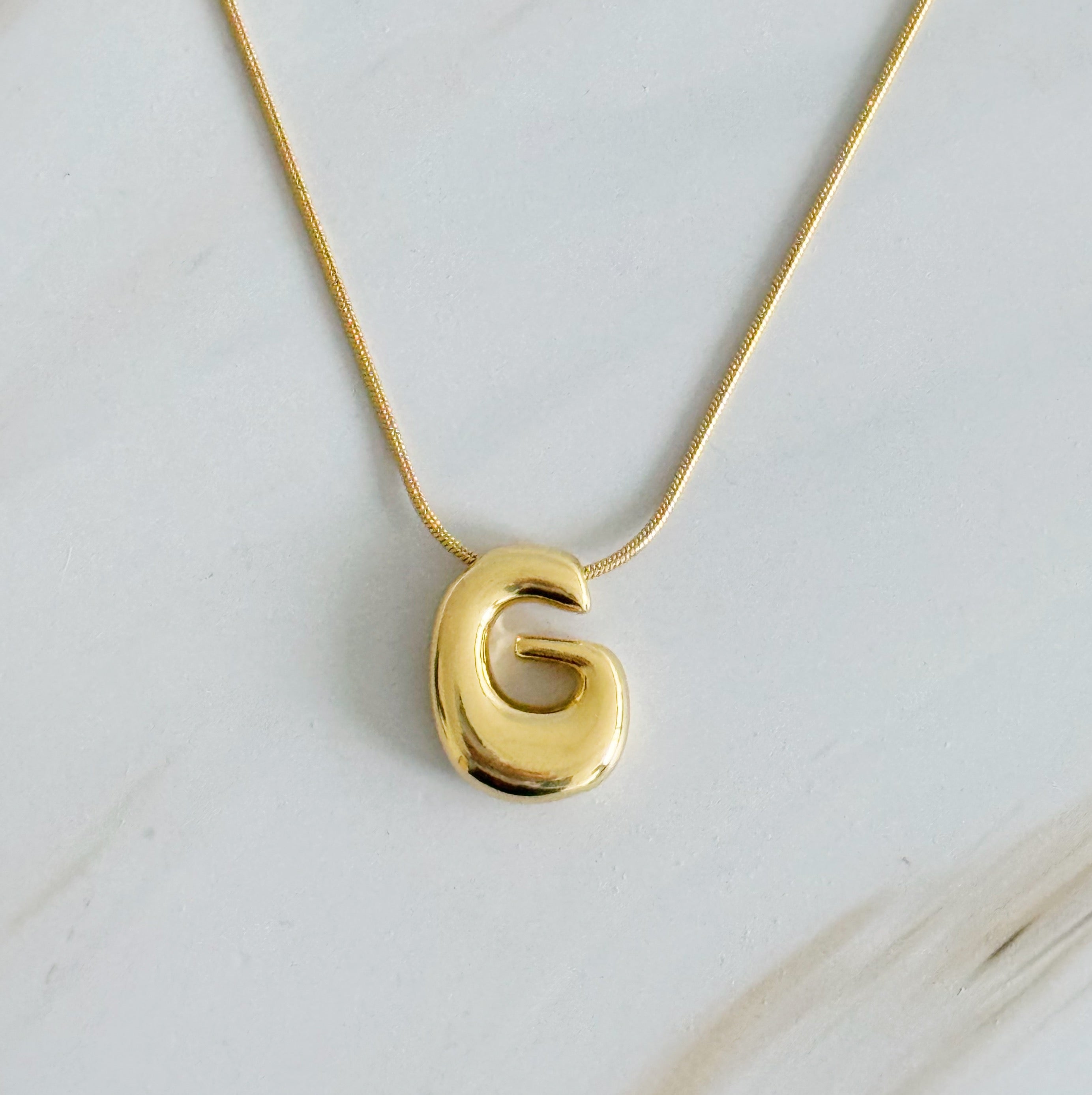 A stylish Balloon Letter Initial Necklace featuring a gold plated initial pendant on a delicate chain.