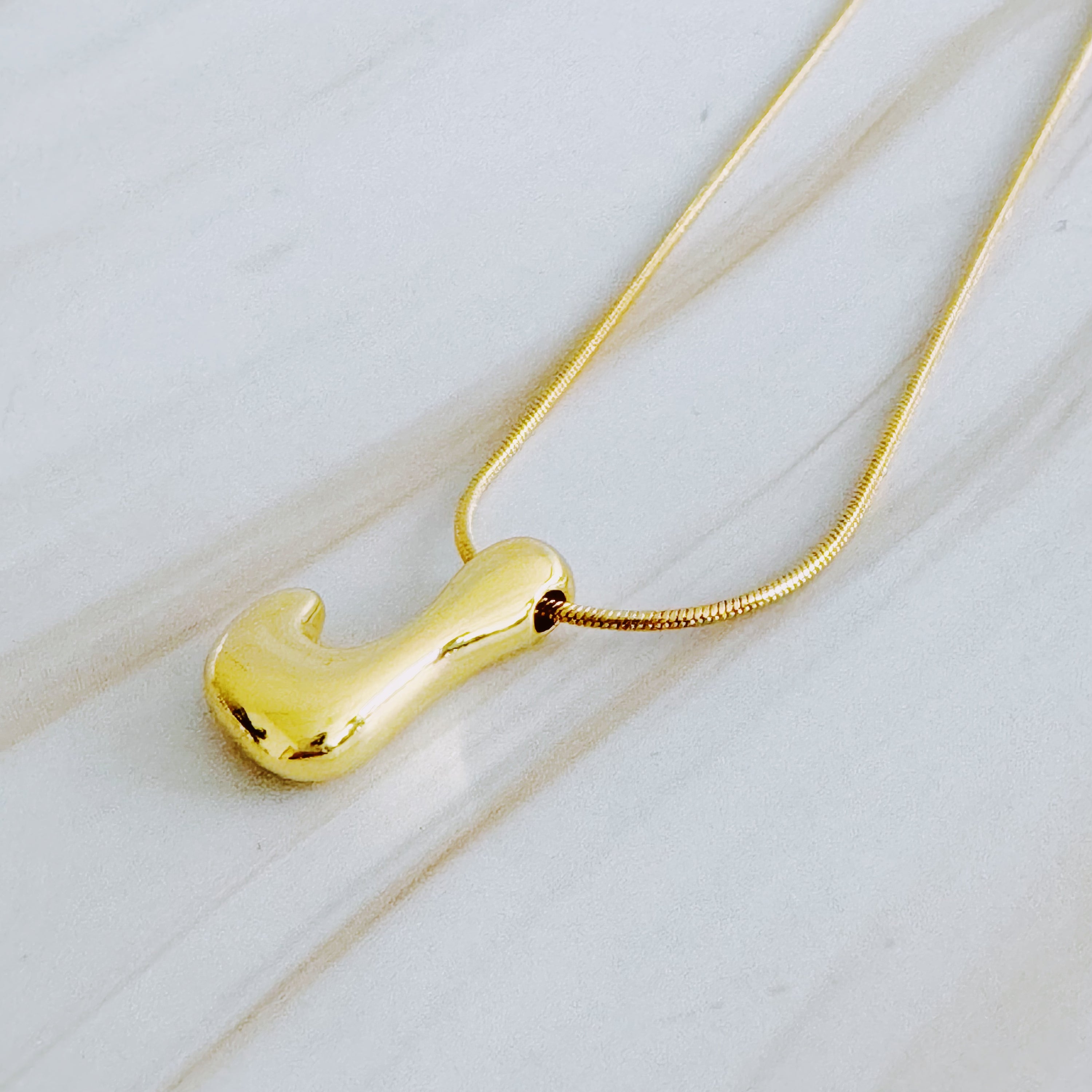 A stylish Balloon Letter Initial Necklace featuring a gold plated initial pendant on a delicate chain.