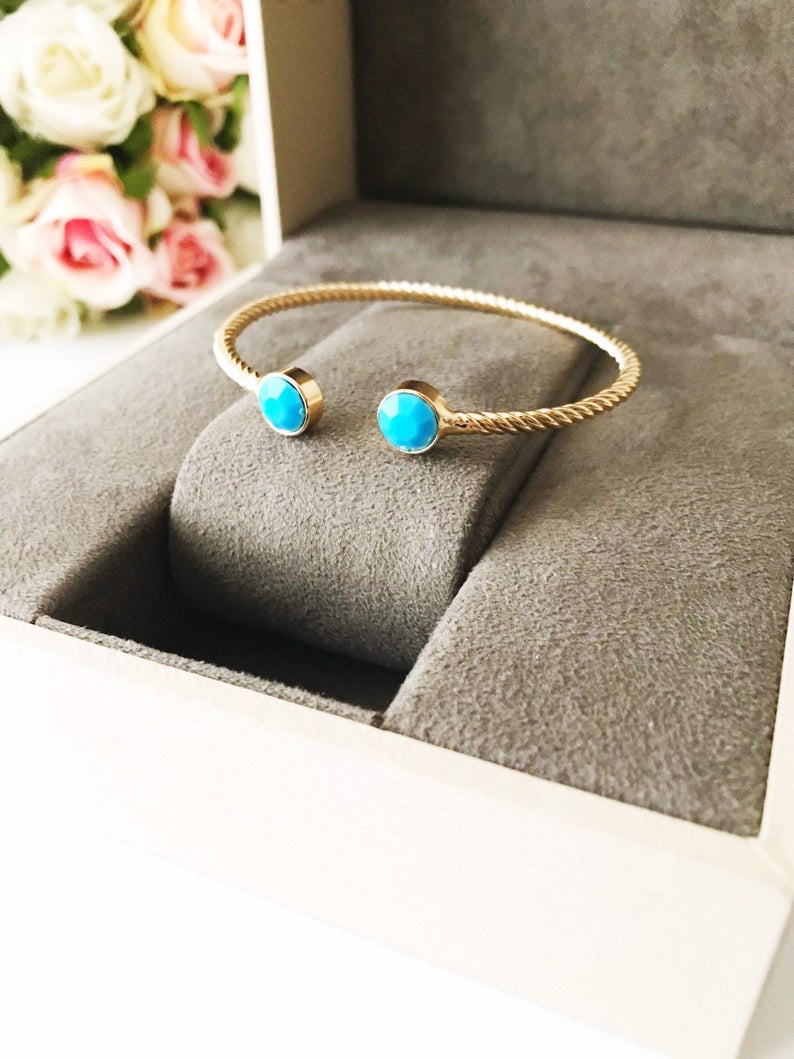 Handmade blue evil eye bangle bracelet with gold accents, featuring an adjustable design and multiple style options.