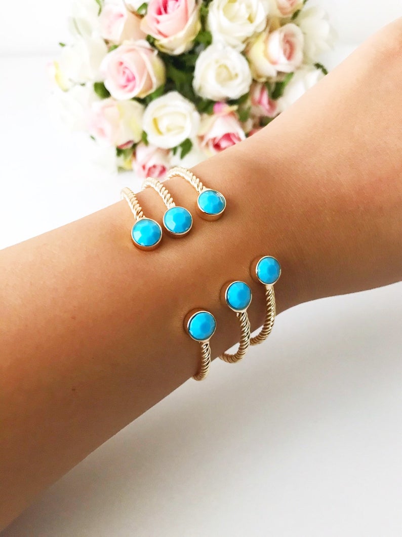 Handmade blue evil eye bangle bracelet with gold accents, featuring an adjustable design and multiple style options.