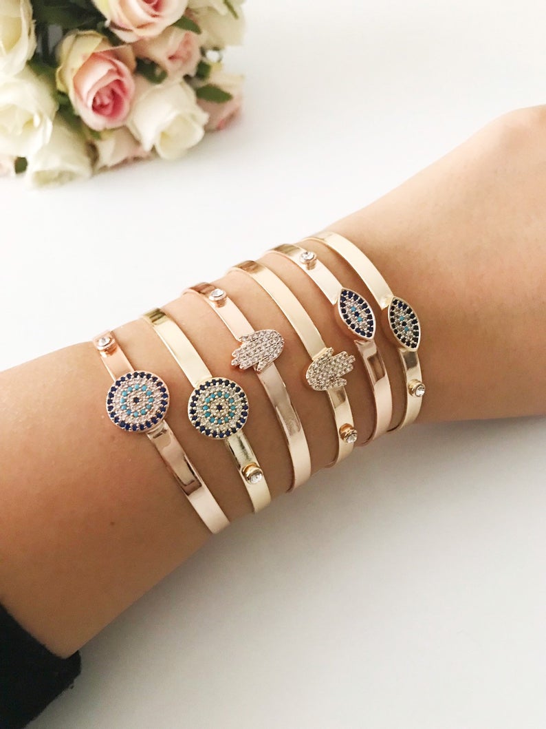 Rose gold Evil Eye Cuff Bracelet featuring a movable oval charm and hamsa hand design, handmade with stainless steel.