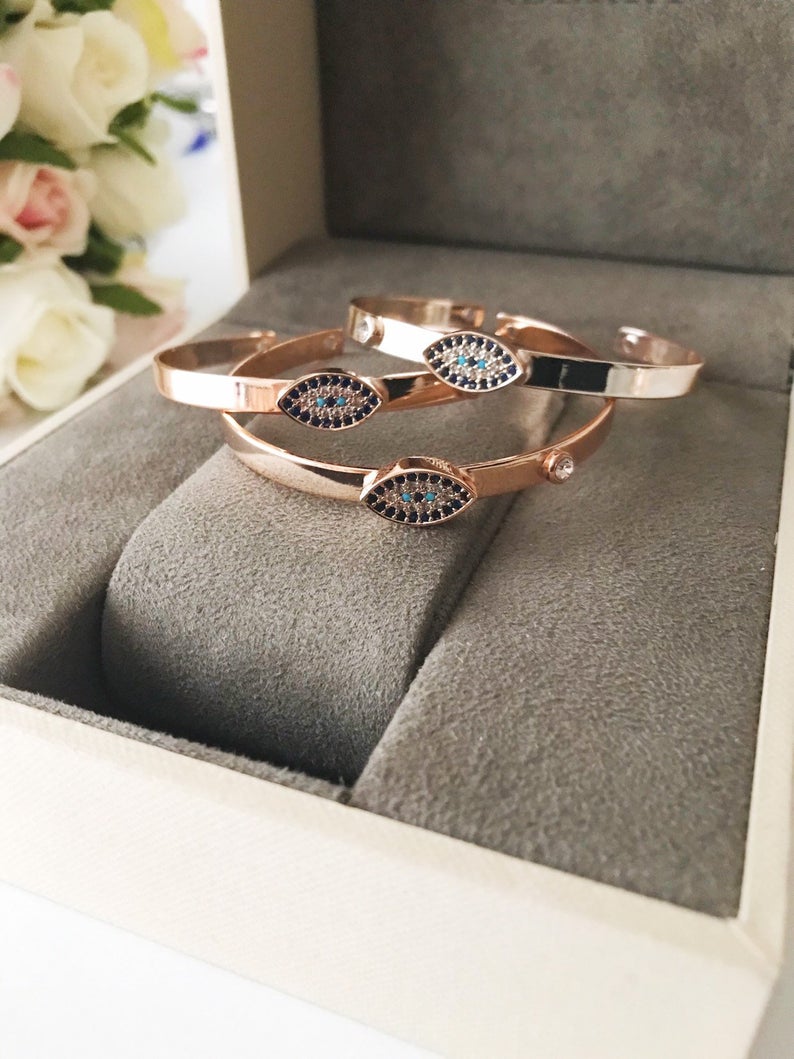 Rose gold Evil Eye Cuff Bracelet featuring a movable oval charm and hamsa hand design, handmade with stainless steel.