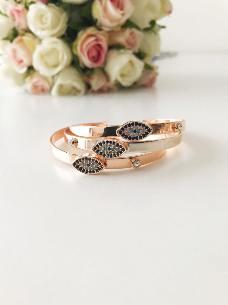 Rose gold Evil Eye Cuff Bracelet featuring a movable oval charm and hamsa hand design, handmade with stainless steel.