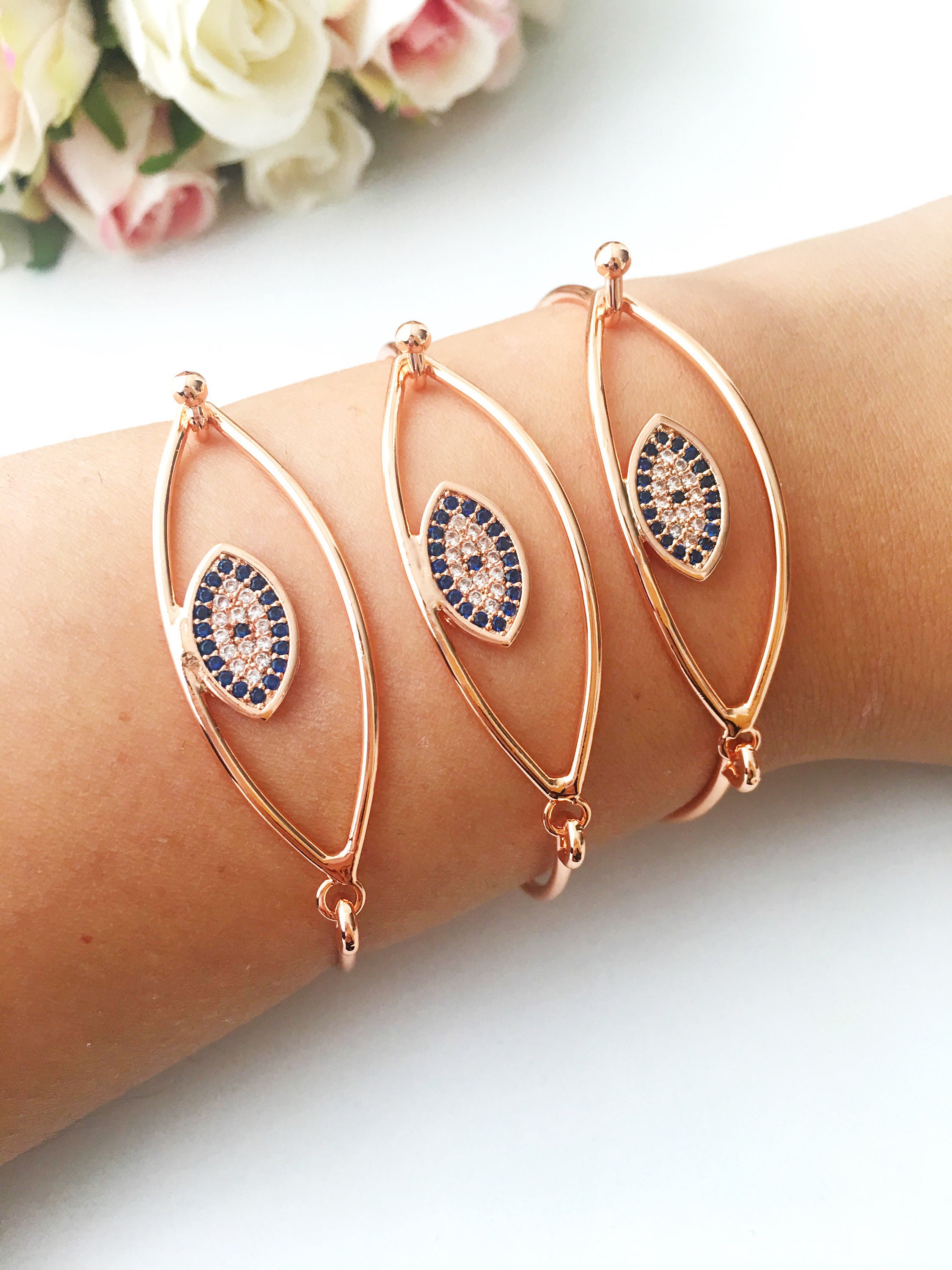 Bangle Evil Eye Bracelet featuring a movable blue evil eye charm on a rose gold stainless steel bangle, showcasing its elegant design.