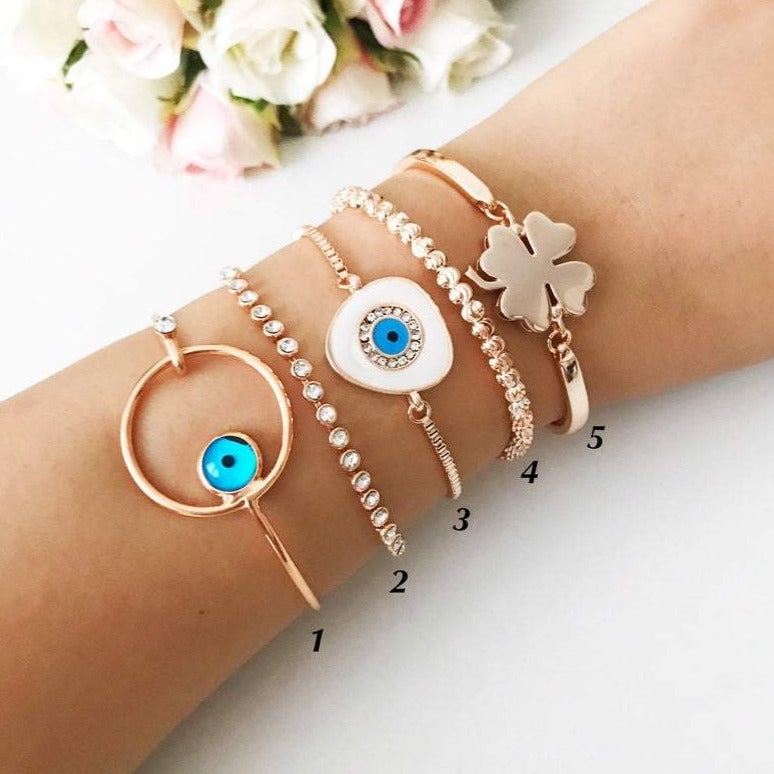 A beautiful rose gold bangle bracelet featuring a movable evil eye charm, showcasing intricate handmade craftsmanship.