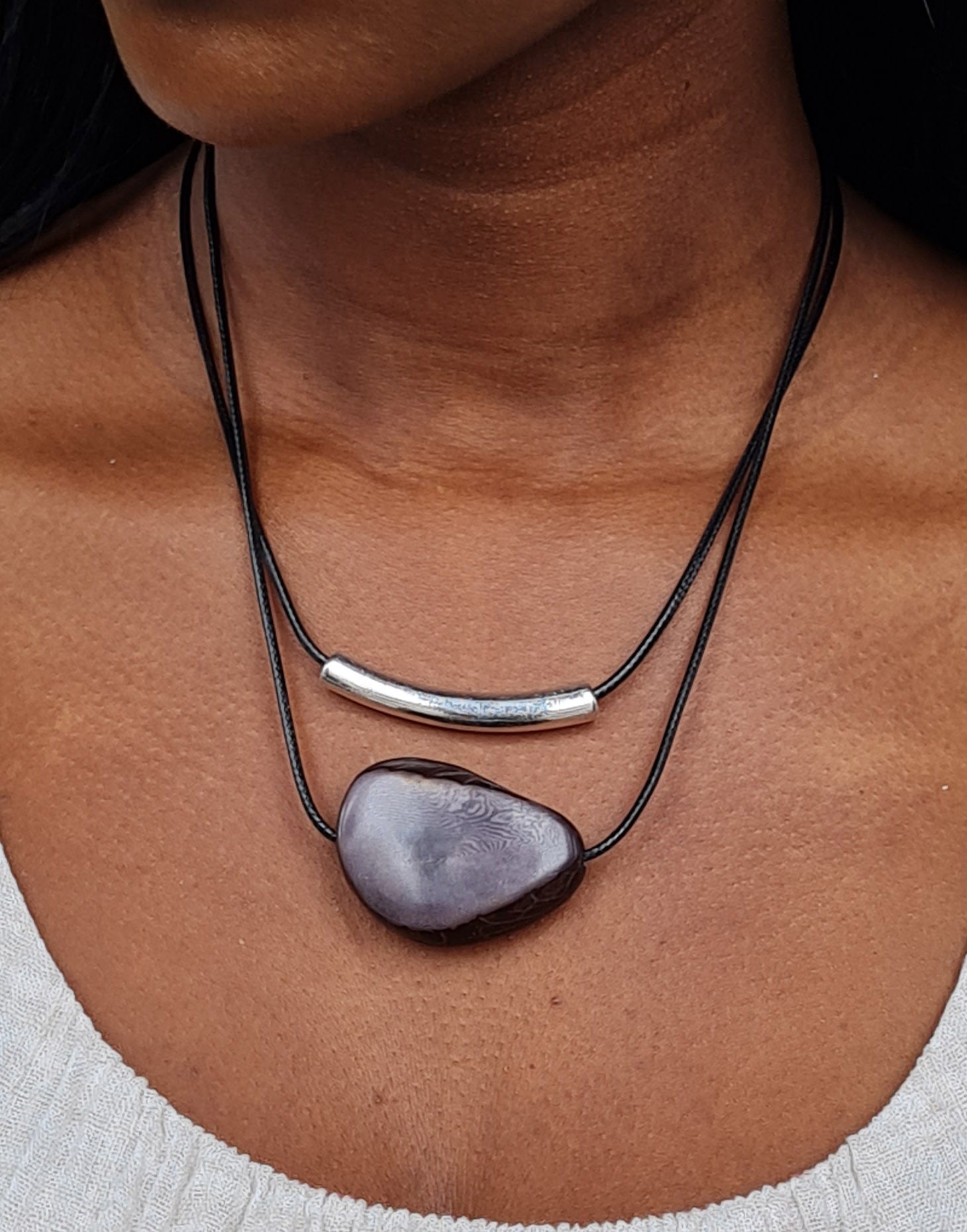 Barra Seed Necklace featuring a silver plated tube and flattened tagua nut, elegantly designed for versatile wear.