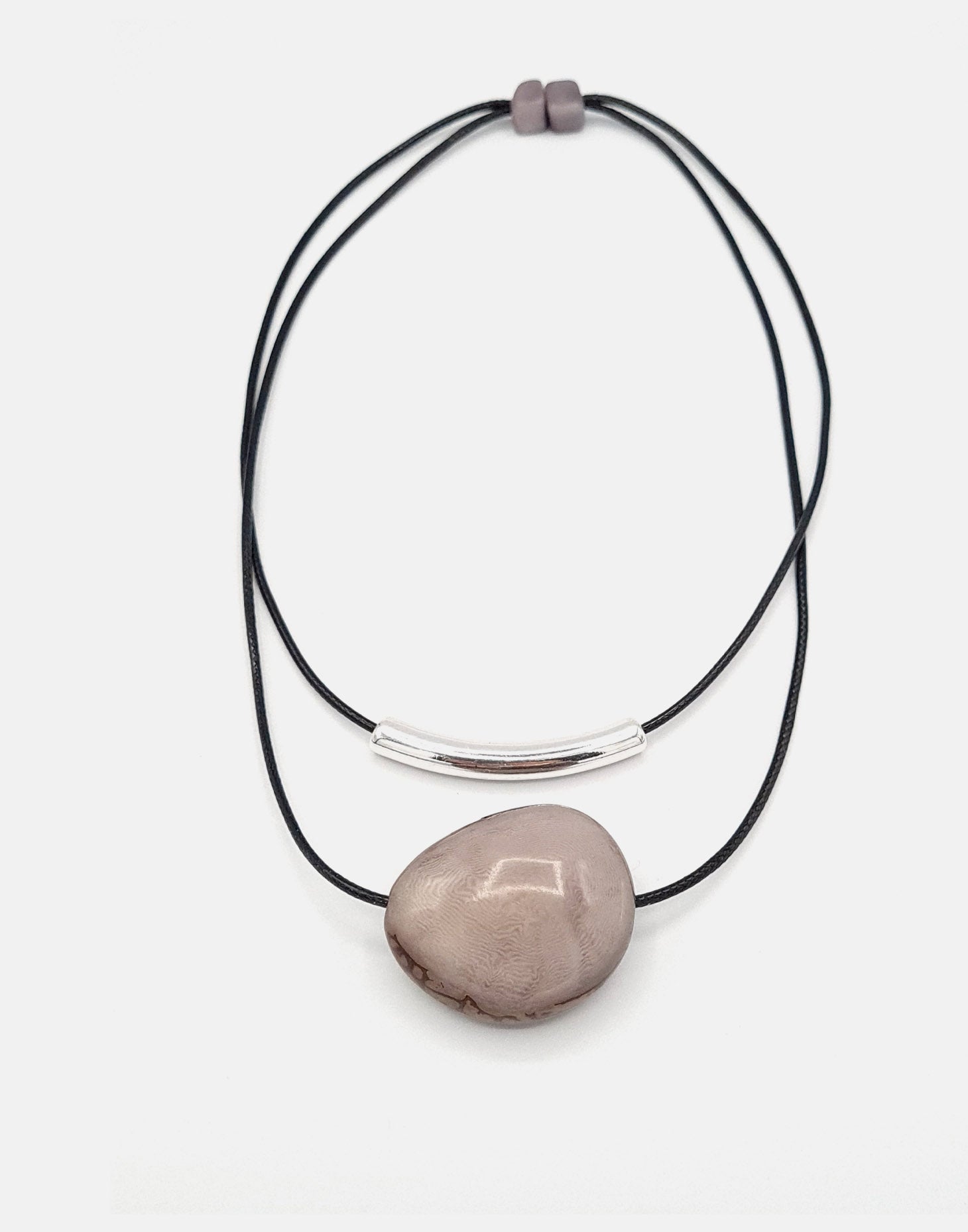 Barra Seed Necklace featuring a silver plated tube and flattened tagua nut, elegantly designed for versatile wear.