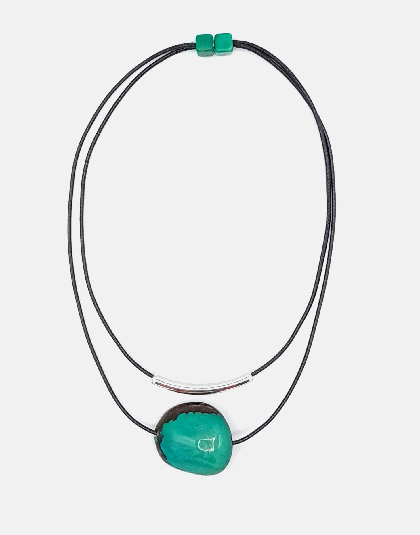 Barra Seed Necklace featuring a silver plated tube and flattened tagua nut, elegantly designed for versatile wear.