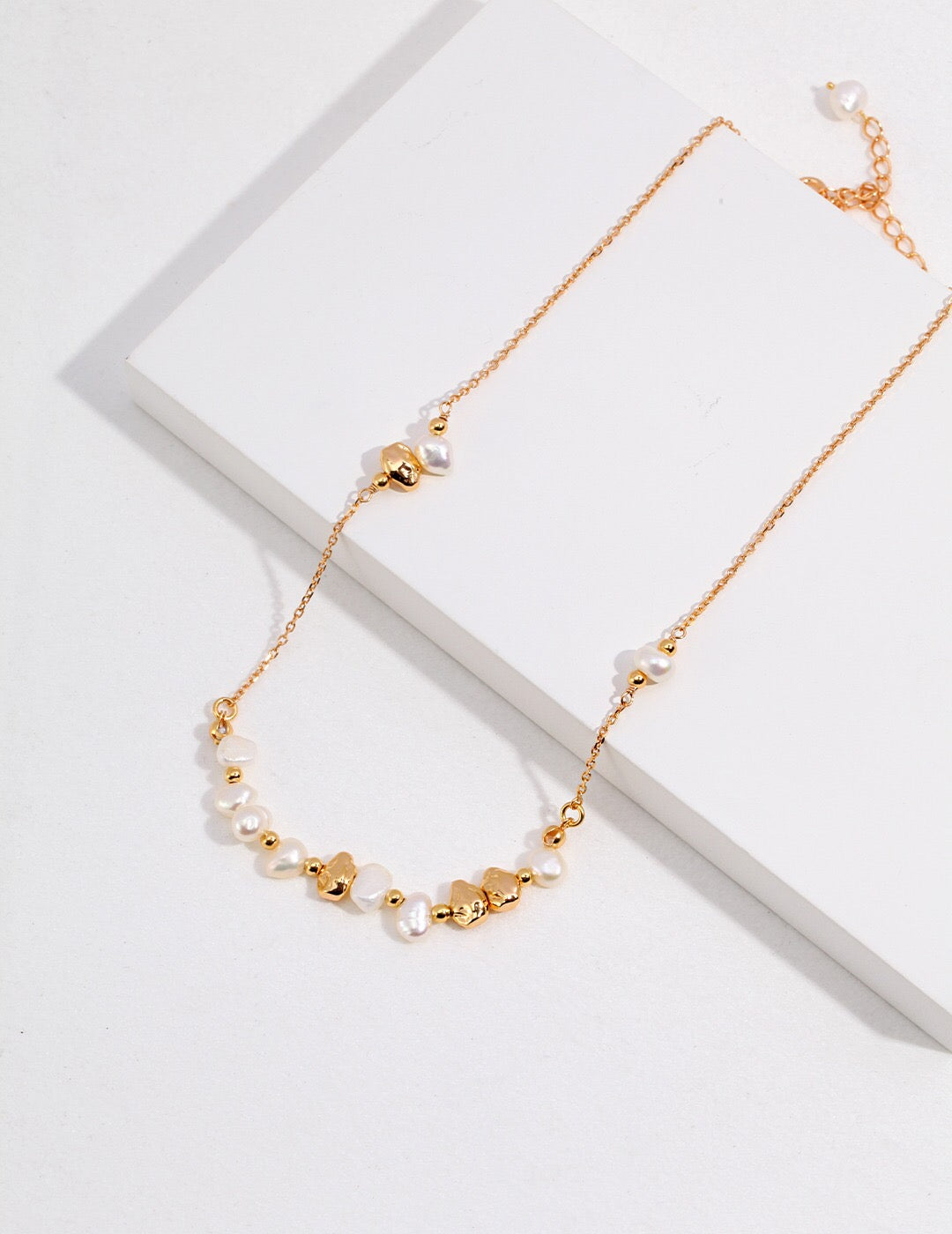 A stunning Baroque Pearl and Irregular Gold Ball Necklace featuring natural pearls and gold vermeil, elegantly displayed on a soft background.