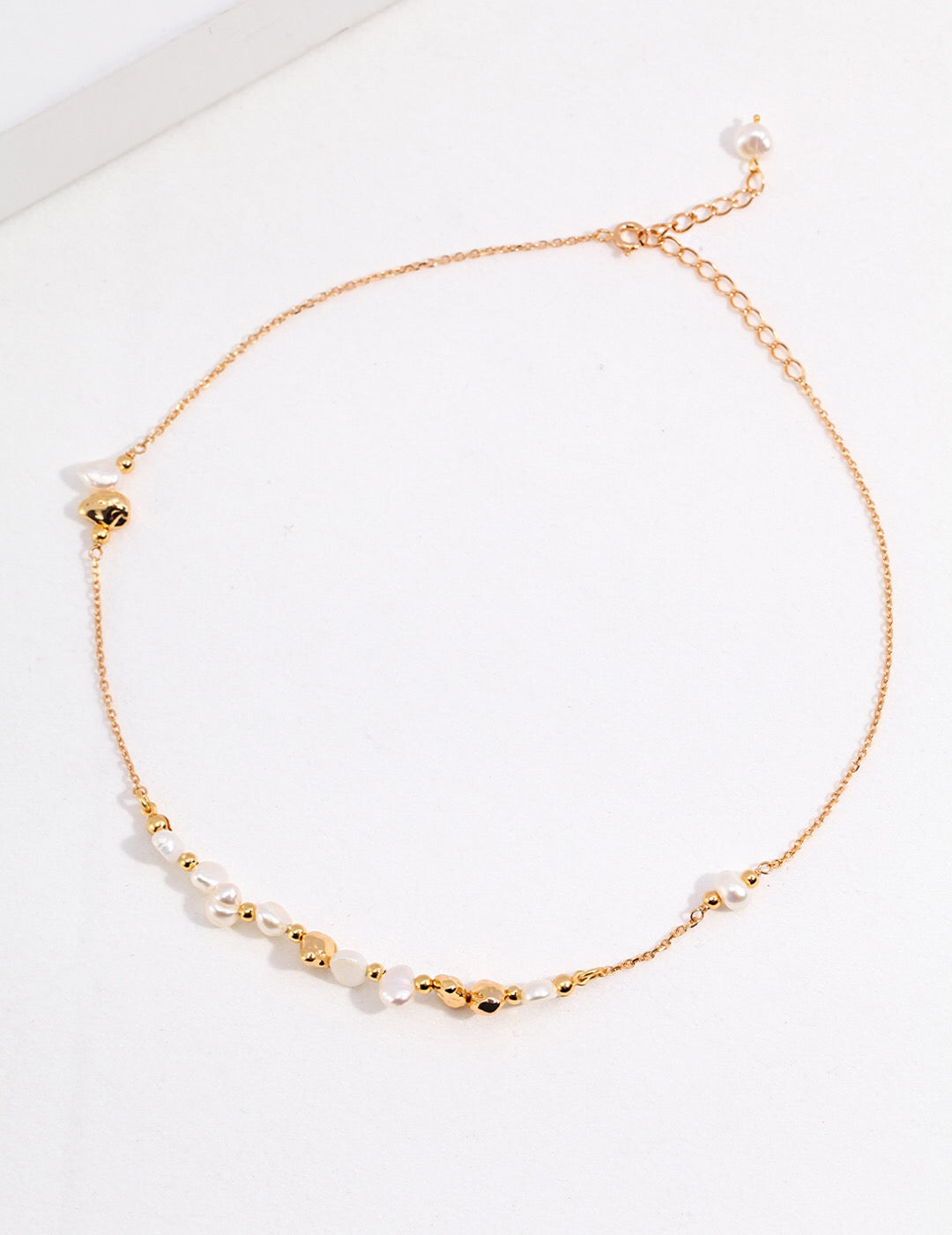 A stunning Baroque Pearl and Irregular Gold Ball Necklace featuring natural pearls and gold vermeil, elegantly displayed on a soft background.