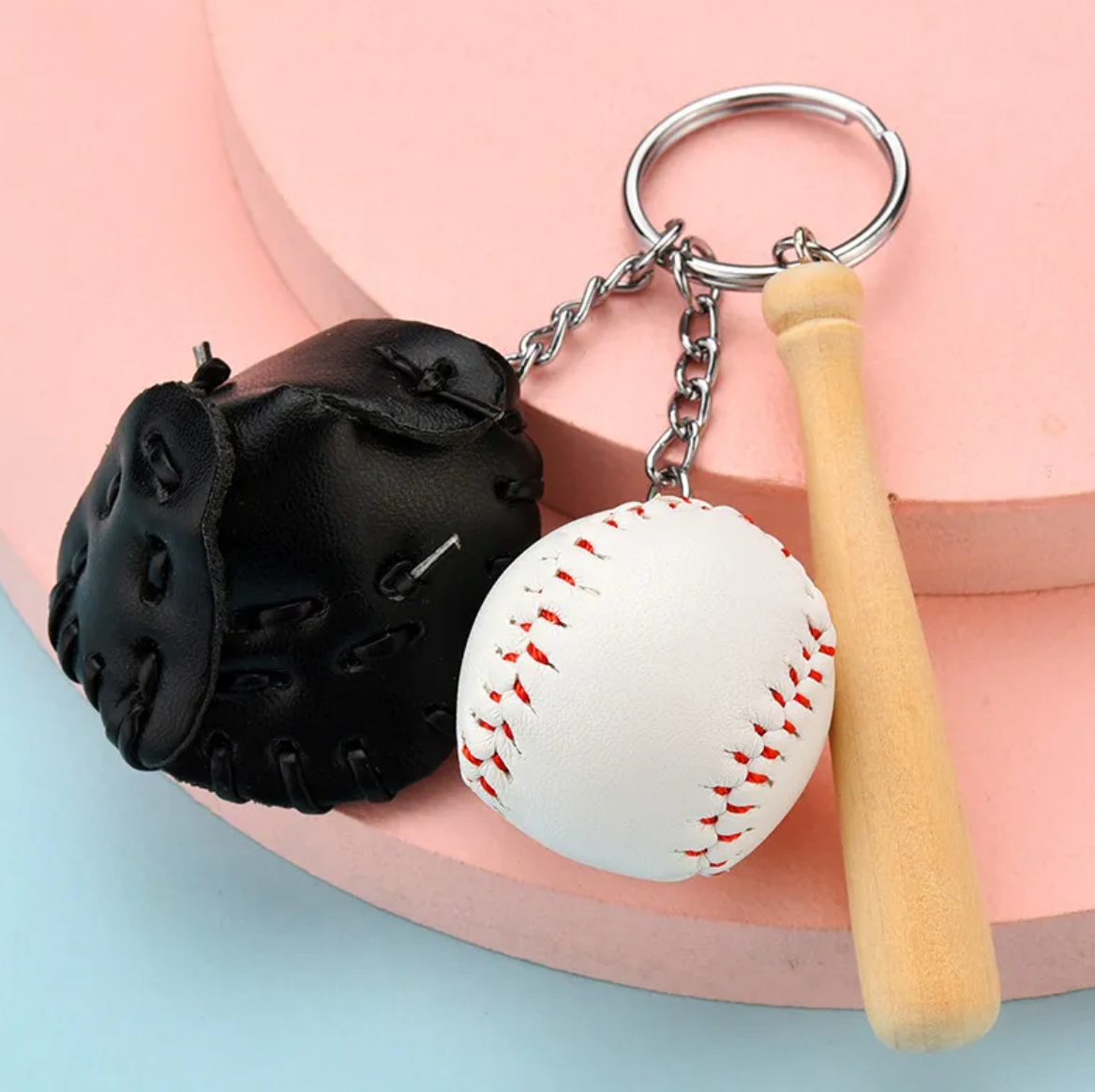 A colorful keychain featuring a miniature baseball bat, ball, and faux leather glove in various colors.