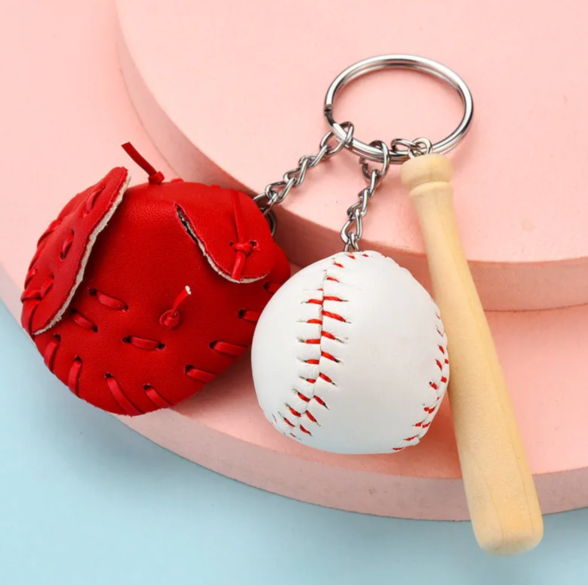 A colorful keychain featuring a miniature baseball bat, ball, and faux leather glove in various colors.