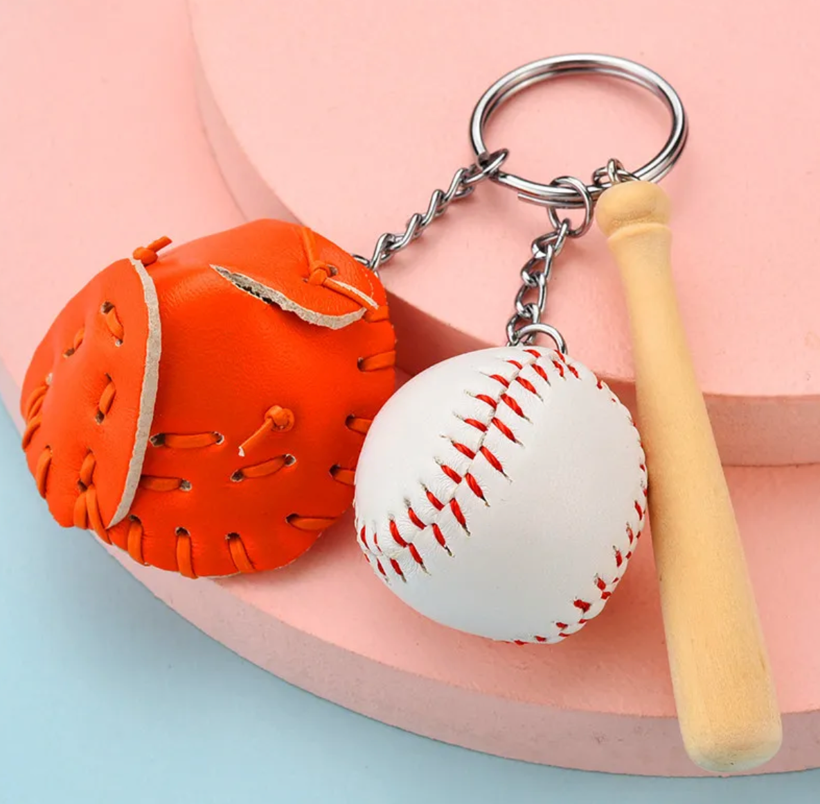 A colorful keychain featuring a miniature baseball bat, ball, and faux leather glove in various colors.