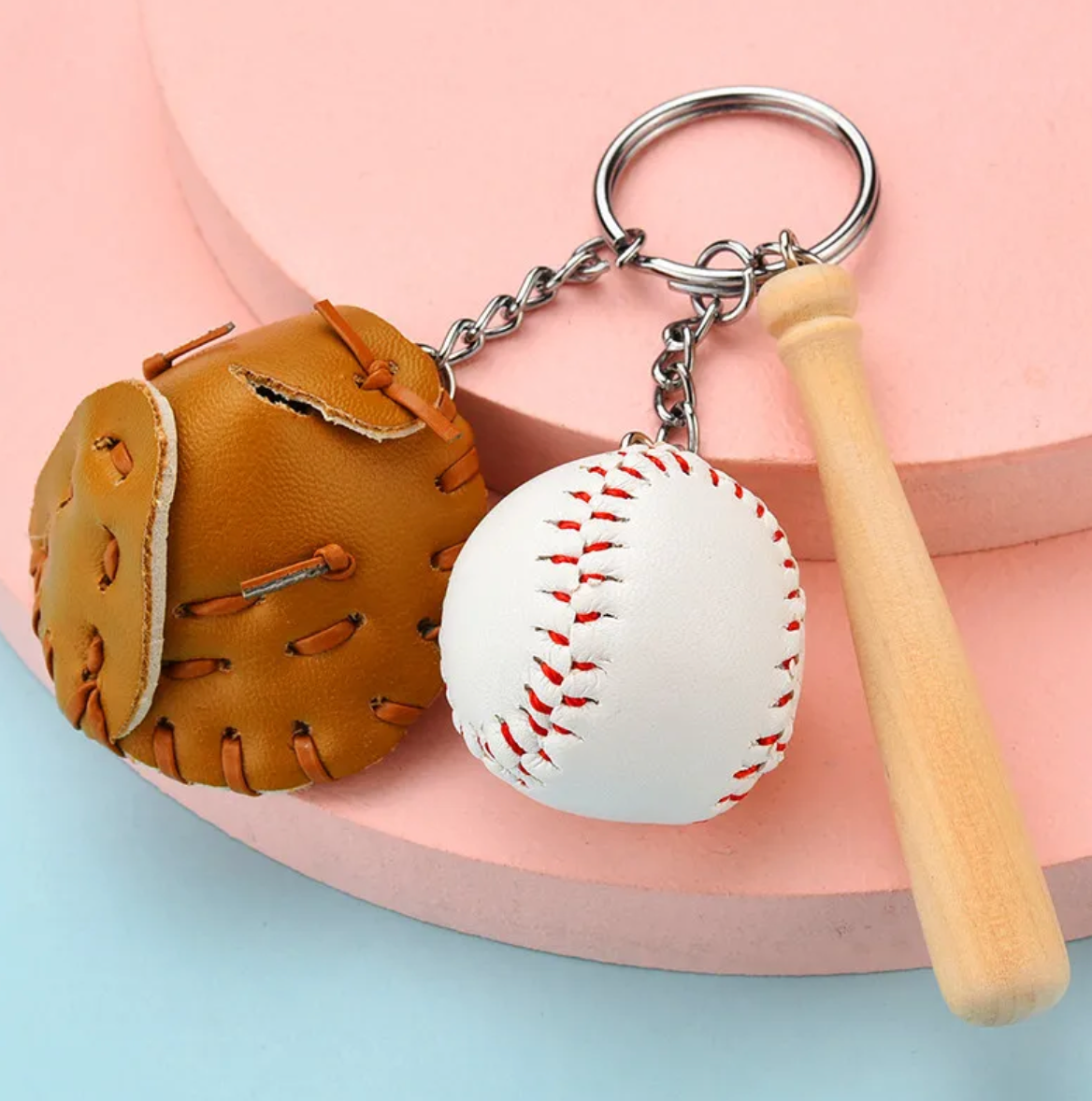 A colorful keychain featuring a miniature baseball bat, ball, and faux leather glove in various colors.