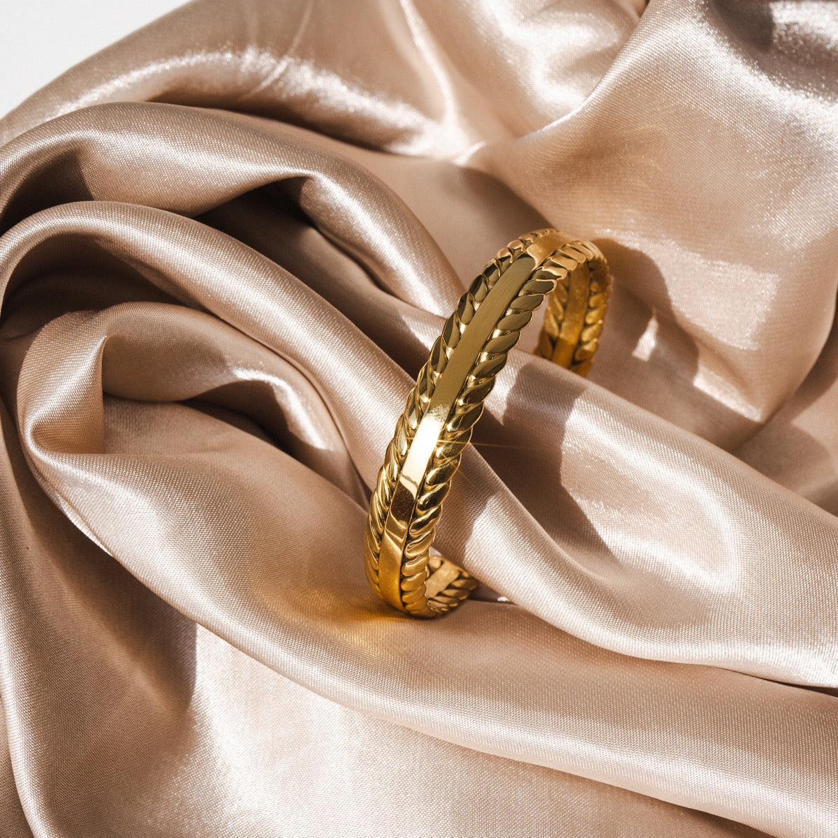 Basma Woven Leaves Bangle featuring intricate woven design and 18k gold plating.