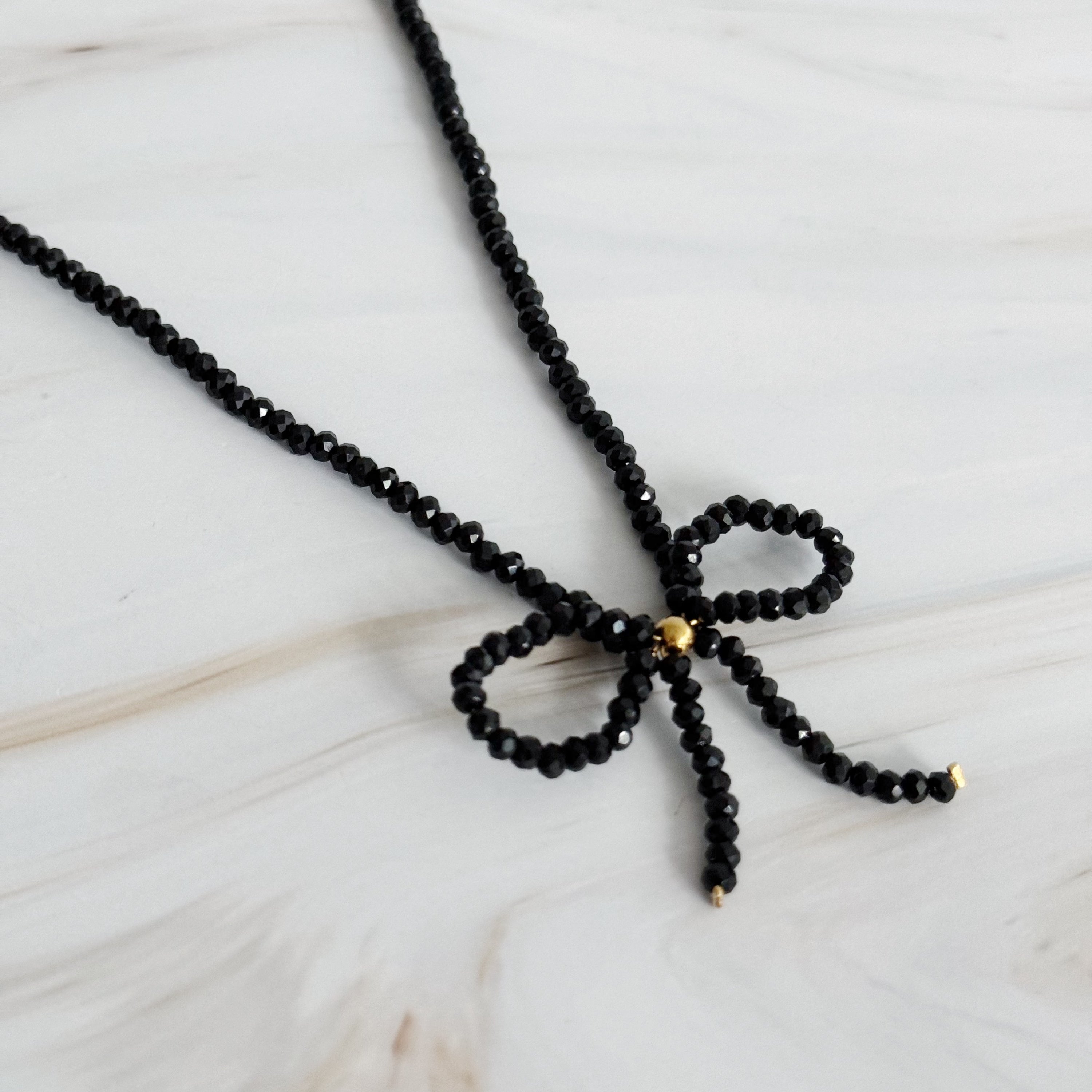 A stunning Beaded Bow Necklace featuring delicate glass beads and an elegant bow design, perfect for any occasion.