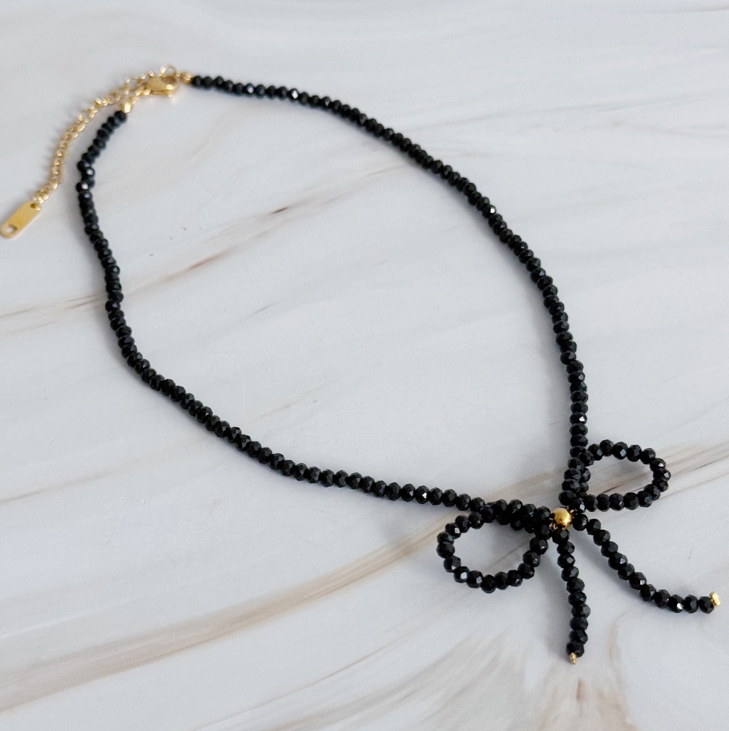 A stunning Beaded Bow Necklace featuring delicate glass beads and an elegant bow design, perfect for any occasion.