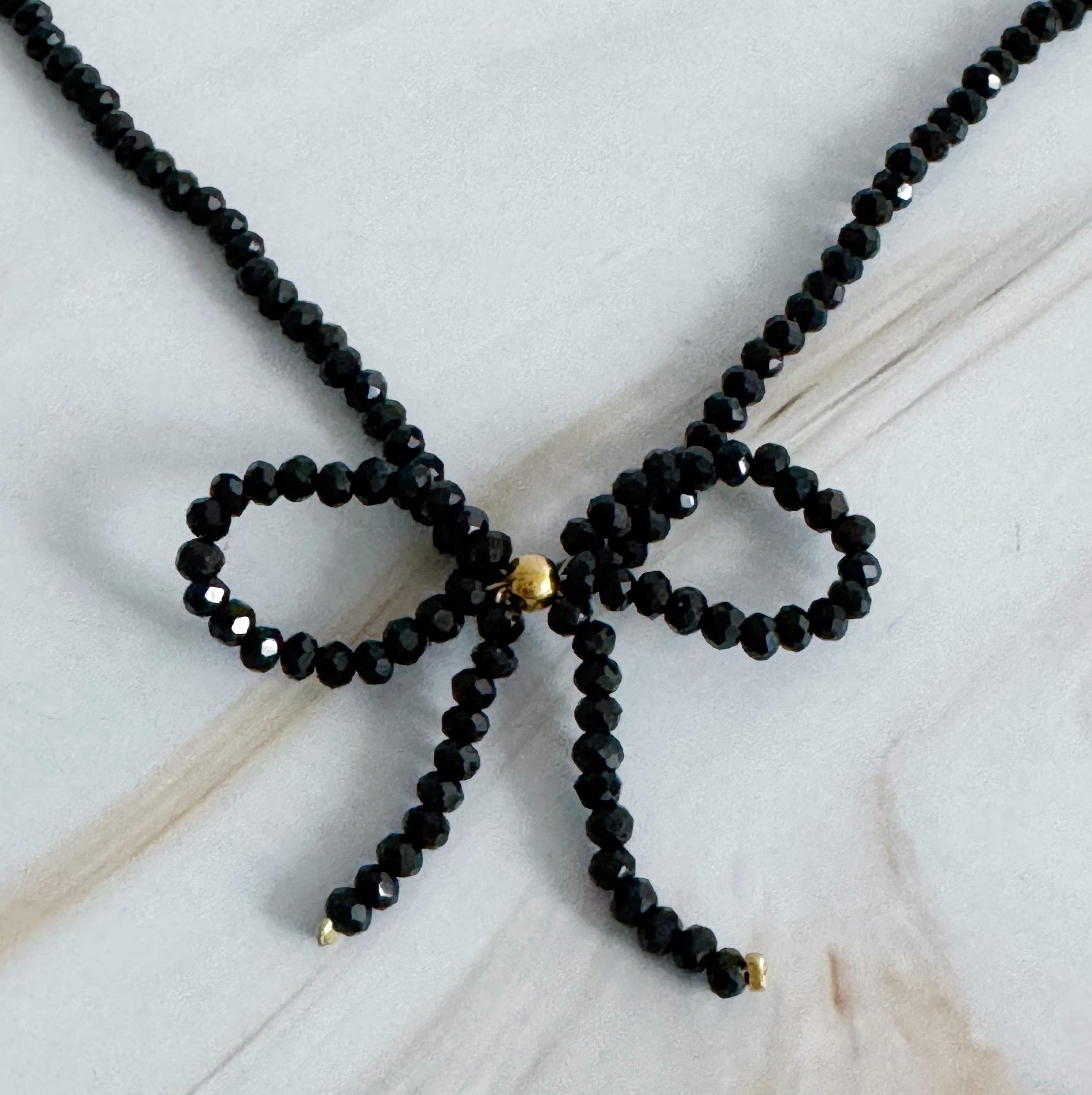 A stunning Beaded Bow Necklace featuring delicate glass beads and an elegant bow design, perfect for any occasion.