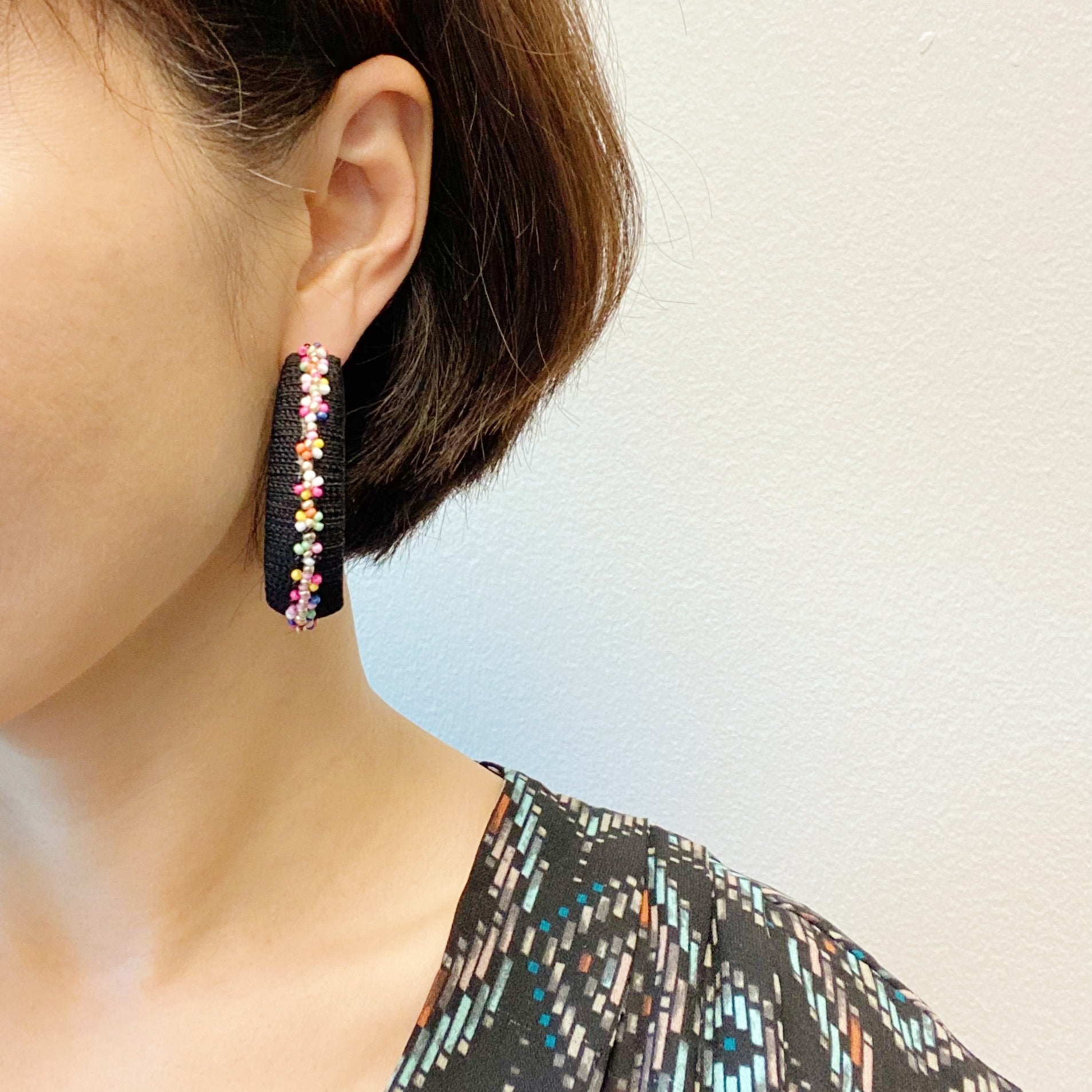 Elegant beaded hoop earrings with flower detailing, showcasing a bold yet classy design.