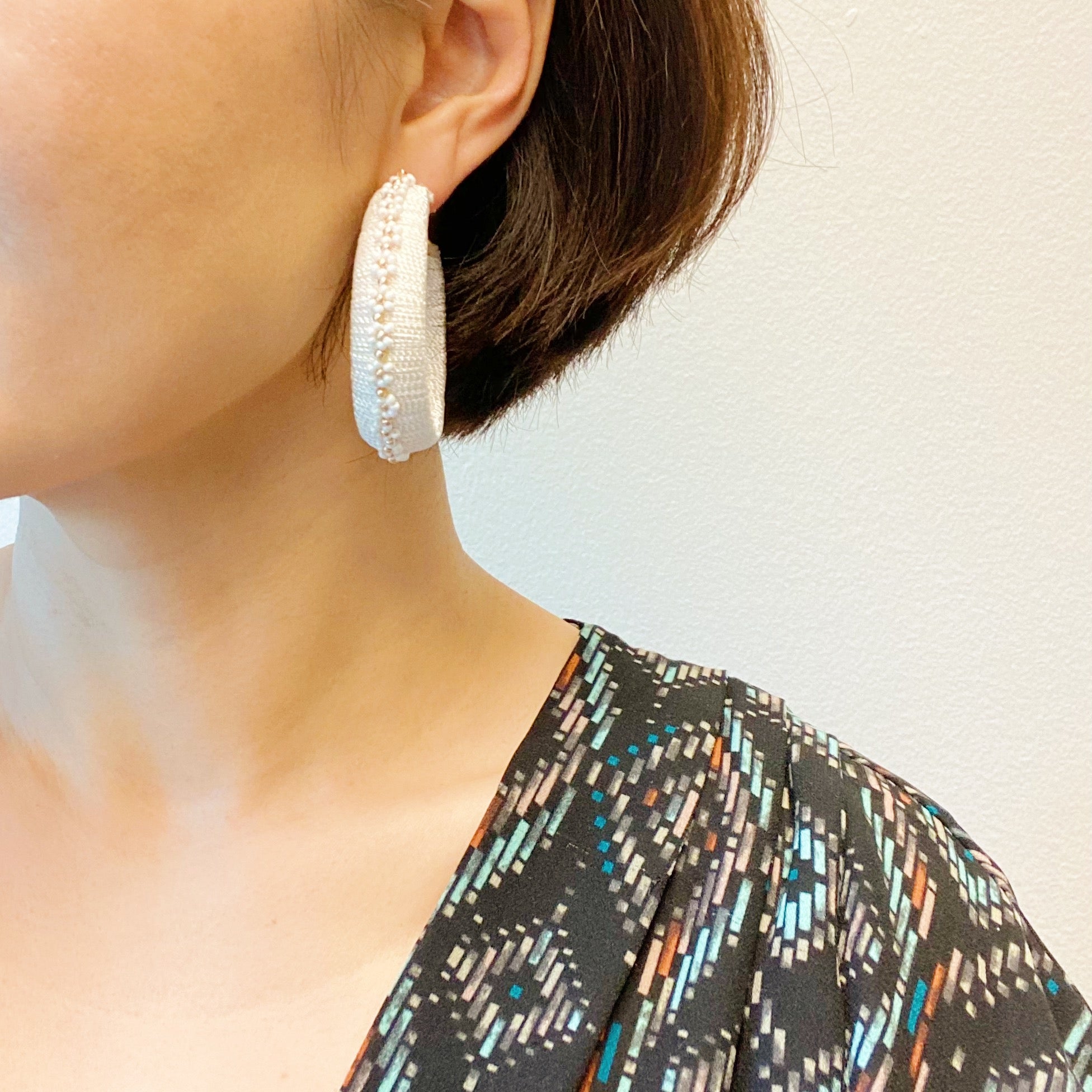 Elegant beaded hoop earrings with flower detailing, showcasing a bold yet classy design.