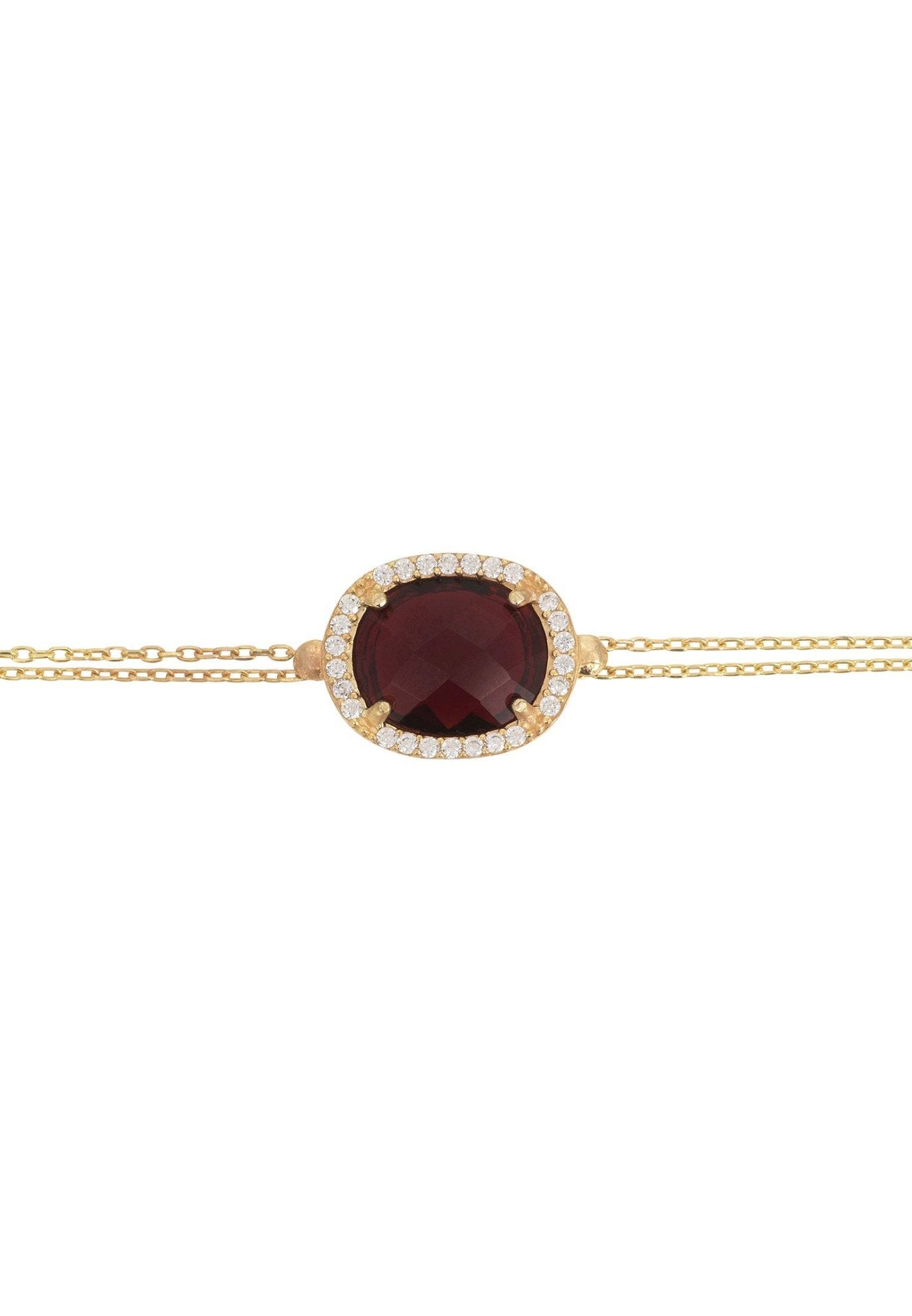 Beatrice Oval Gemstone Bracelet featuring a multifaceted garnet surrounded by cubic zirconia on a gold plated double chain.