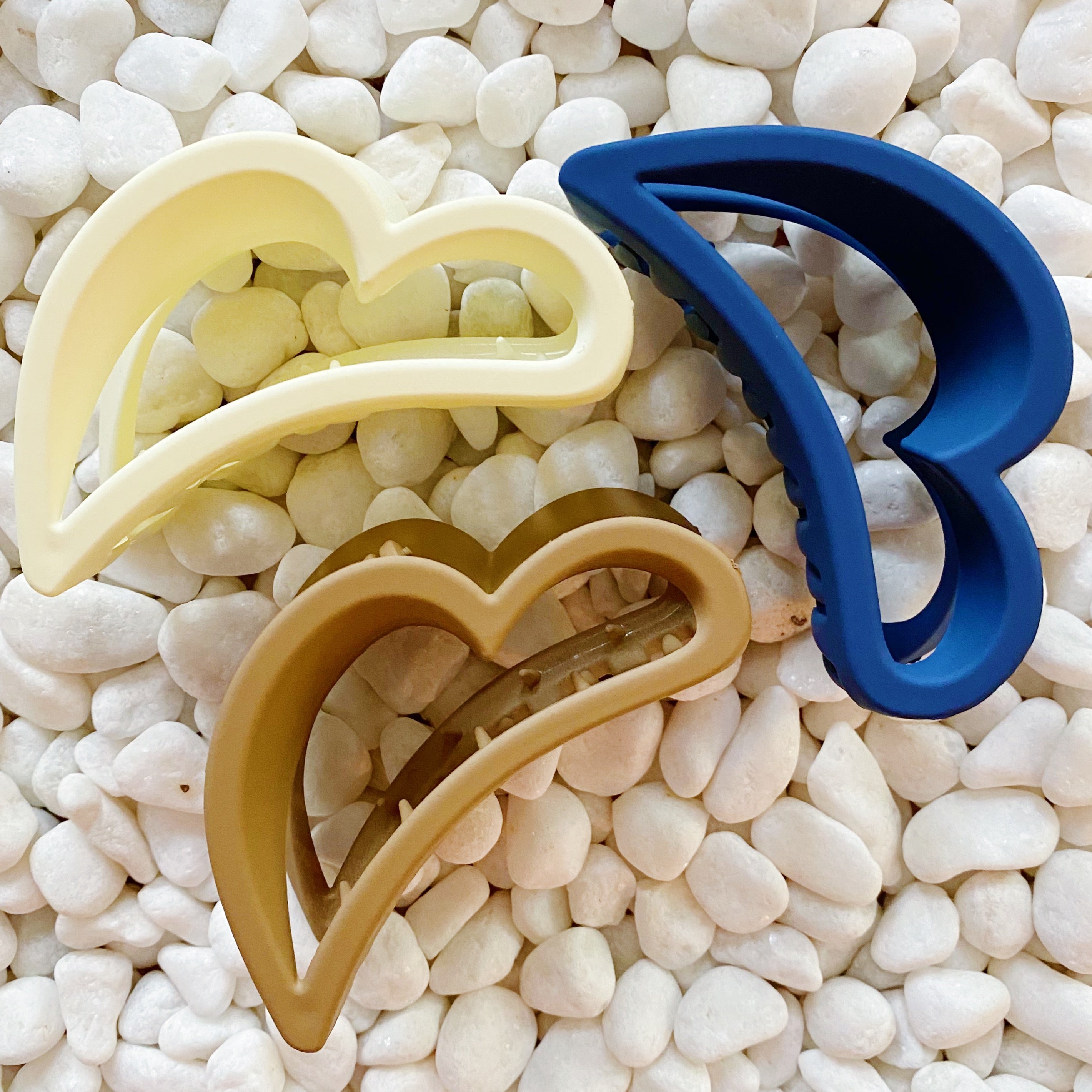 Set of three heart-shaped hair claws in matte colors, showcasing their playful design and functionality.