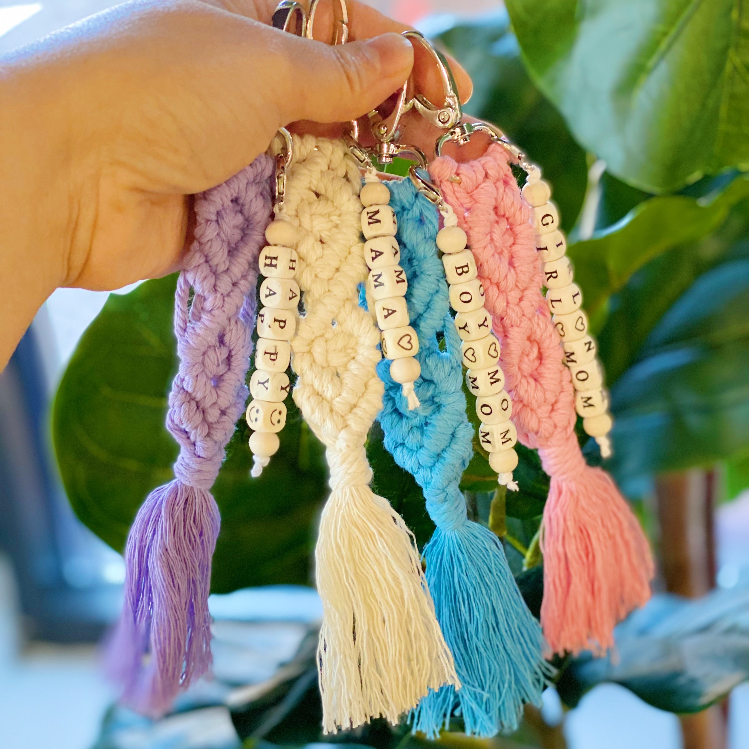 A stylish macrame braided key chain featuring empowering wooden cube beads, showcasing a bohemian design.